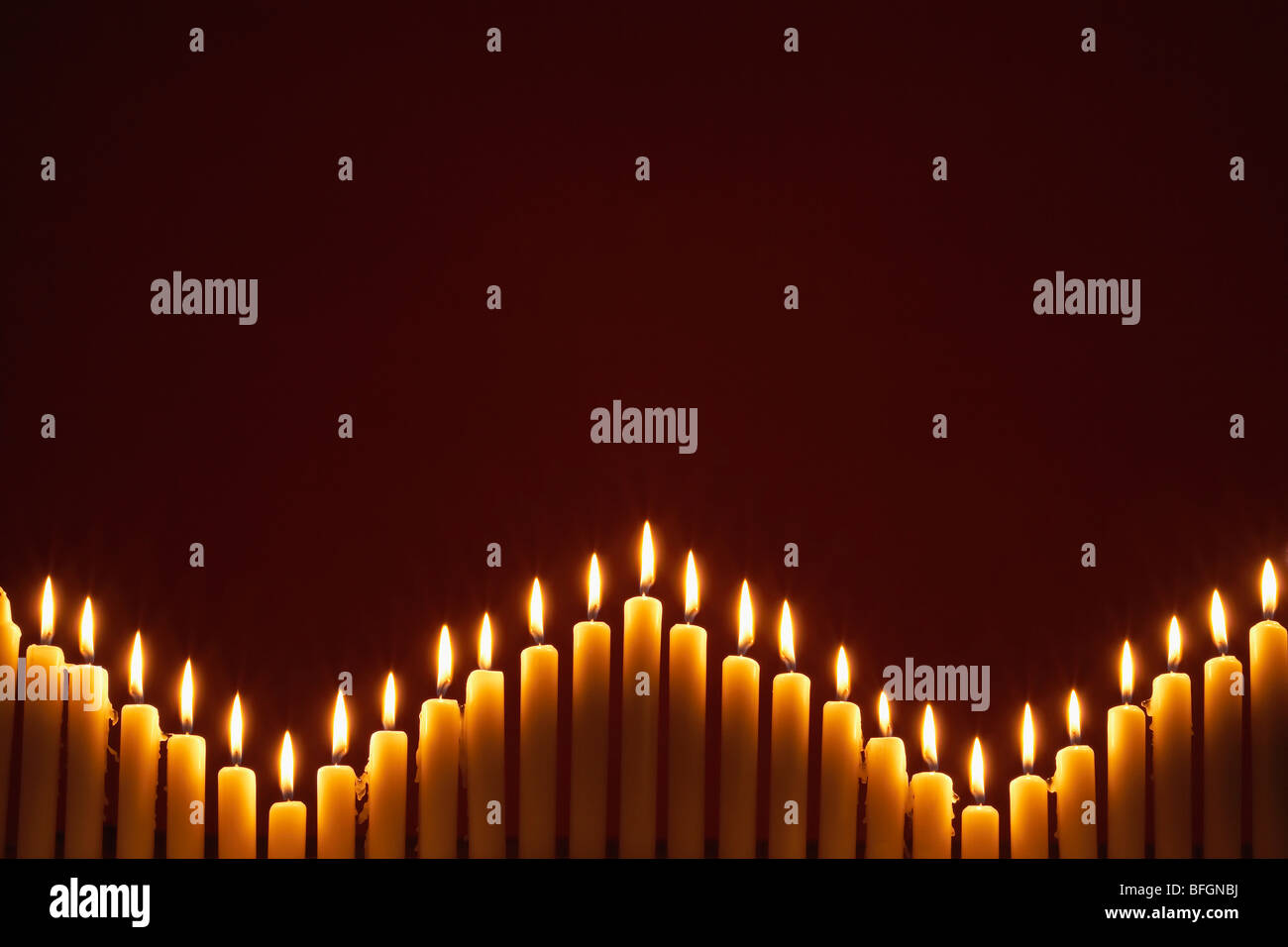 Row of lit candles, on black background Stock Photo - Alamy