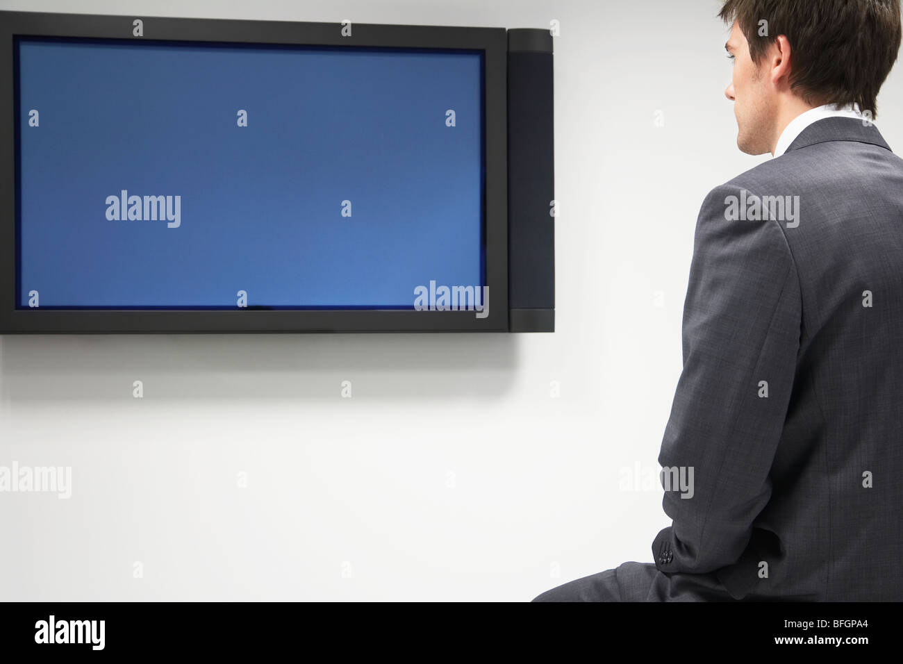 Businessman Looking at Flat Panel Television Stock Photo