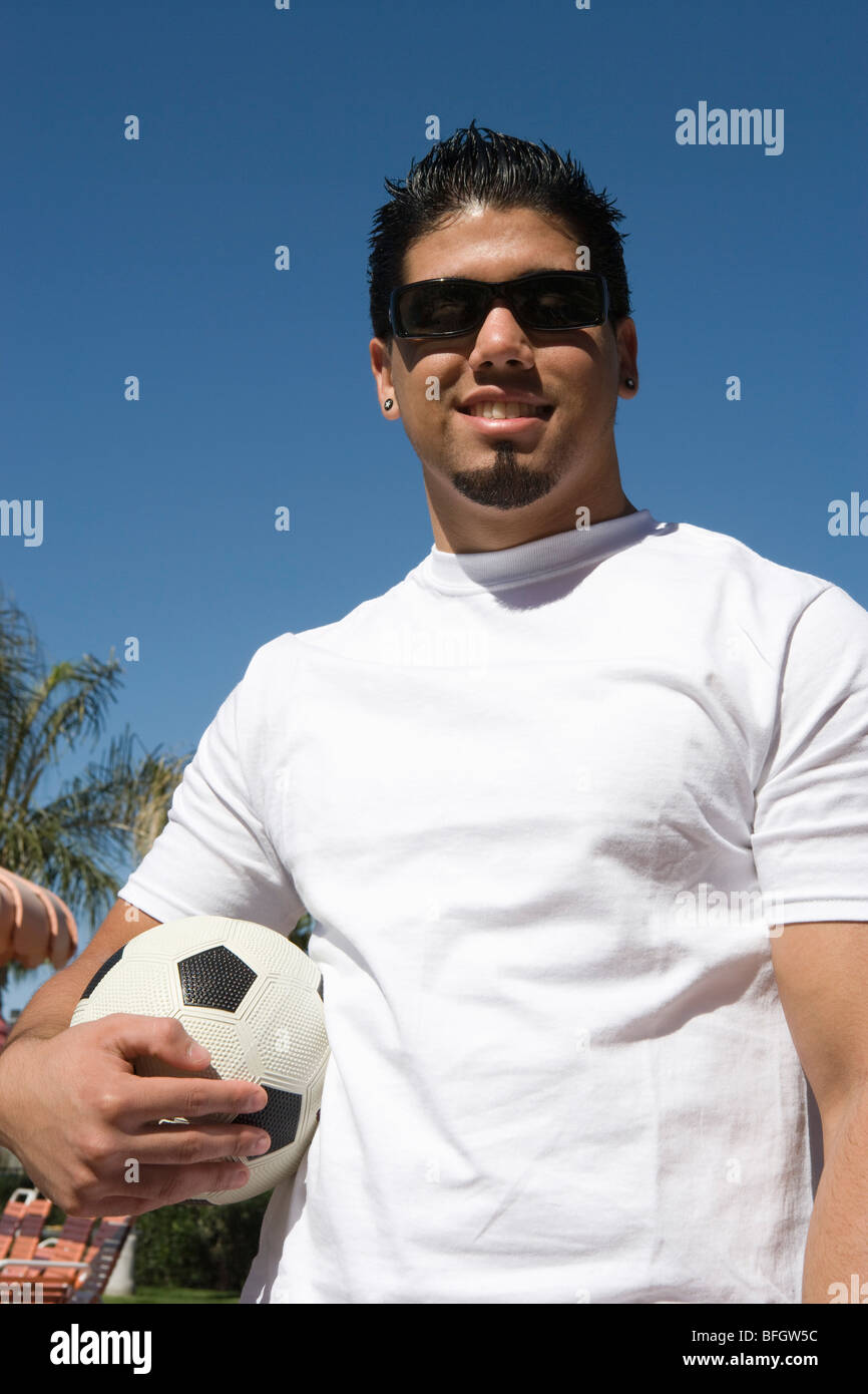 Young man holding soccer ball outdoors, portrait Stock Photo - Alamy