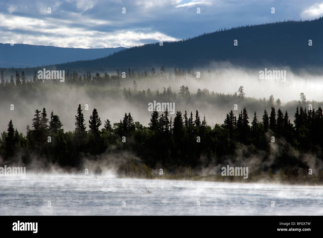 Fog over Yukon River with Gray Mountain in the background. Yukon Territory, Canada Stock Photo
