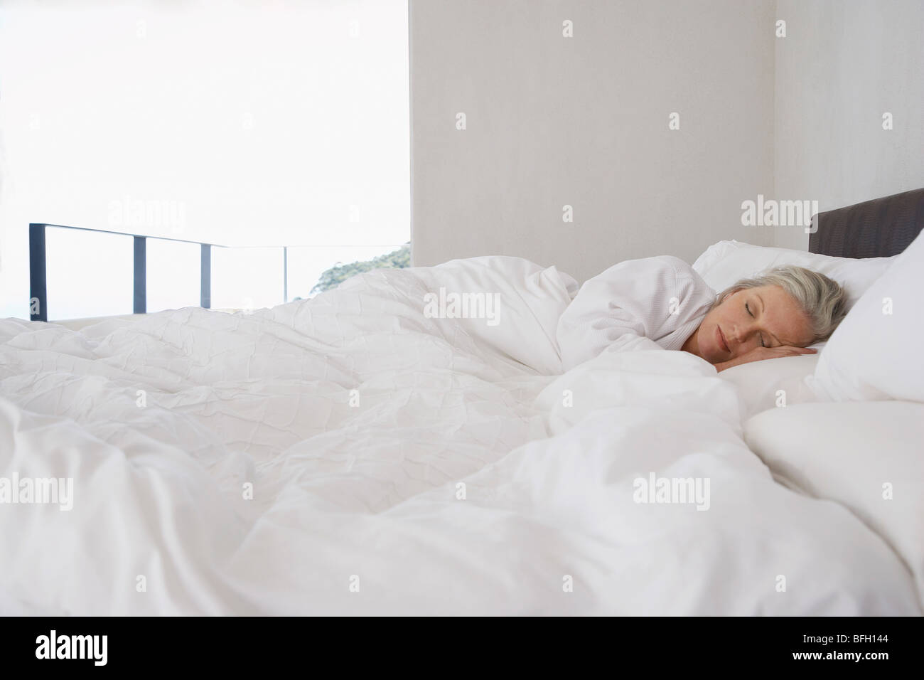 Mature woman lying asleep in bed Stock Photo Alamy