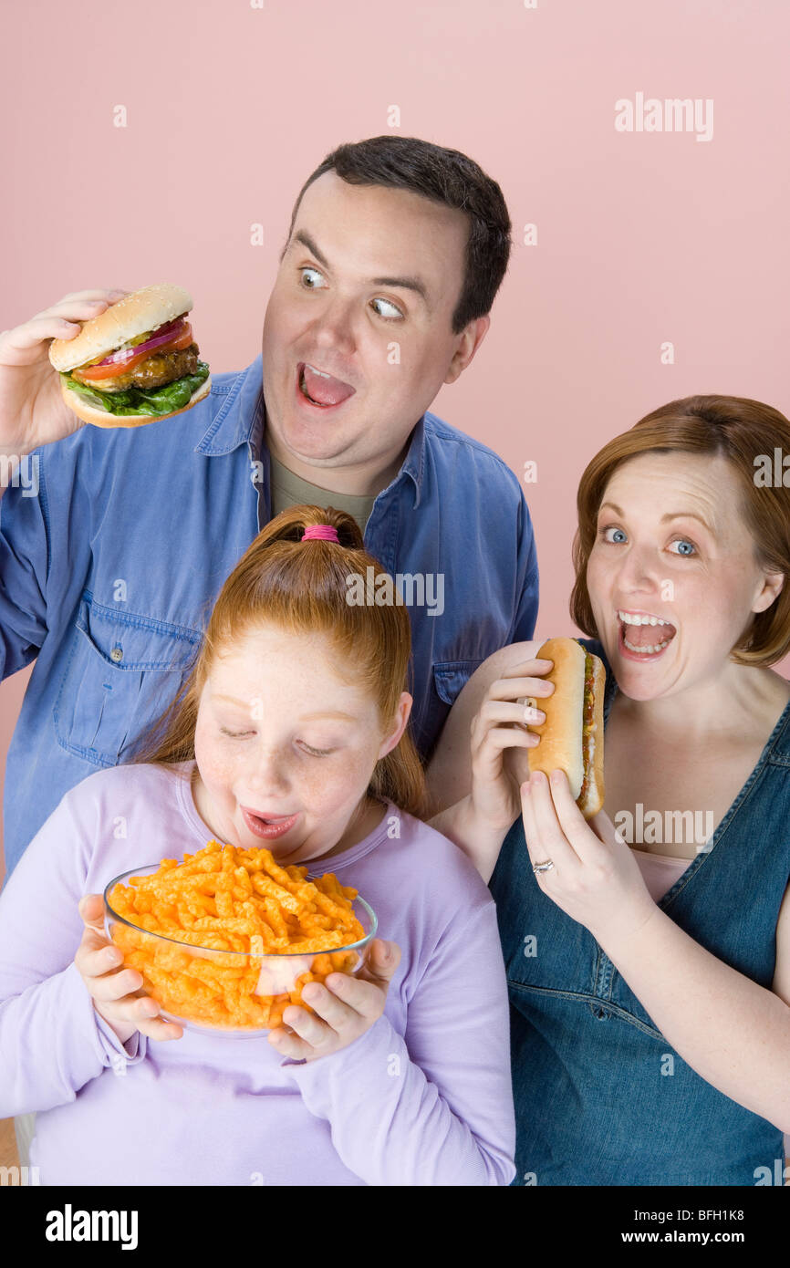 Overweight family holding unhealthy food Stock Photo