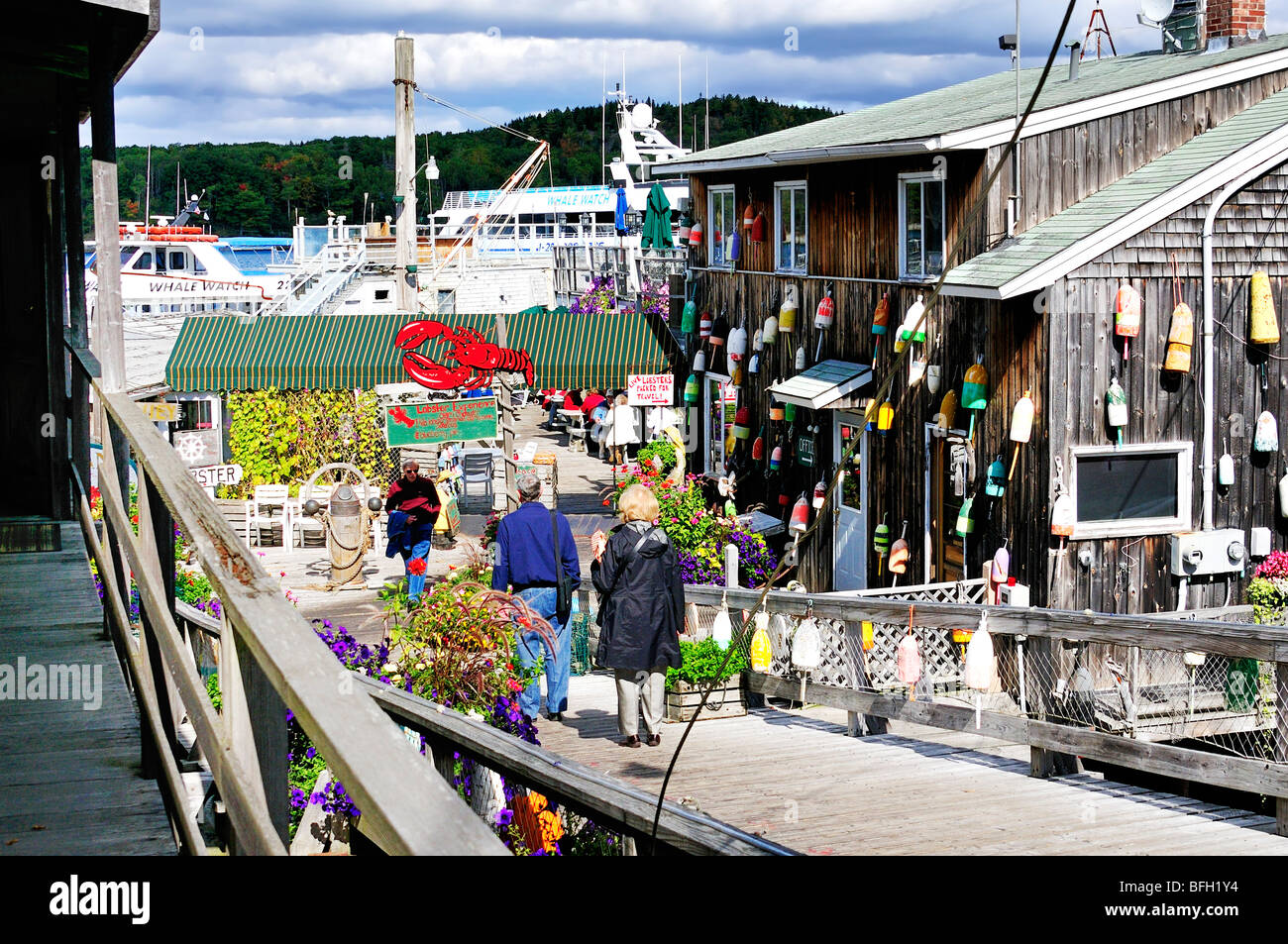 Tourists walk down a gangplank to a seafood restaurant on Frenchman's Bay, Bar Harbor, Maine, USA. Stock Photo