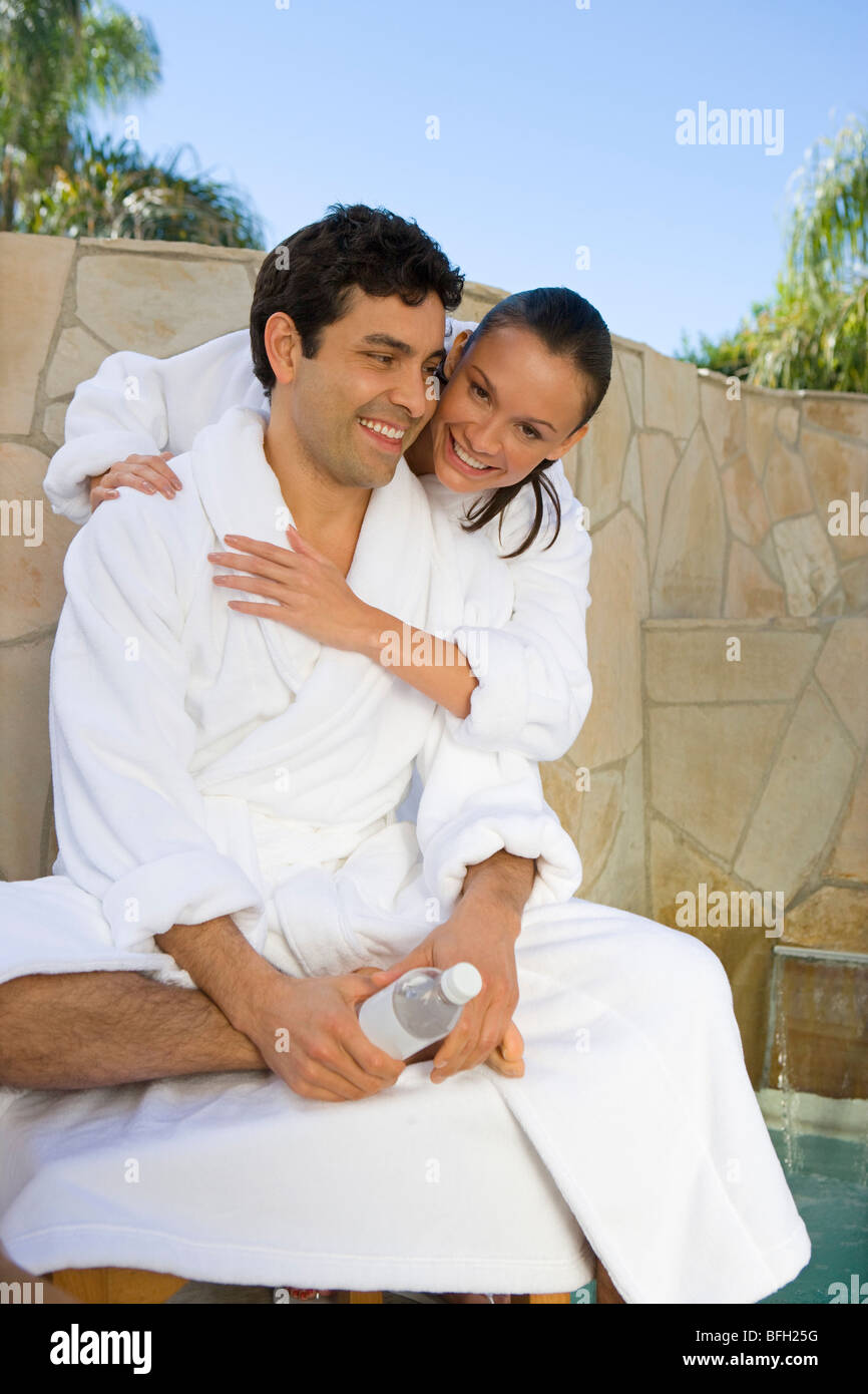 Couple relaxing by swimming pool Stock Photo - Alamy