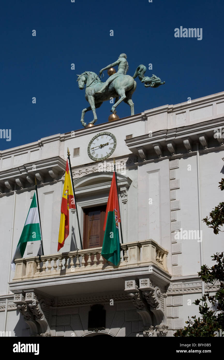 Front of town hall building in Granada with horse statue on roof and Spanish and Andalusian flags on balcony Stock Photo