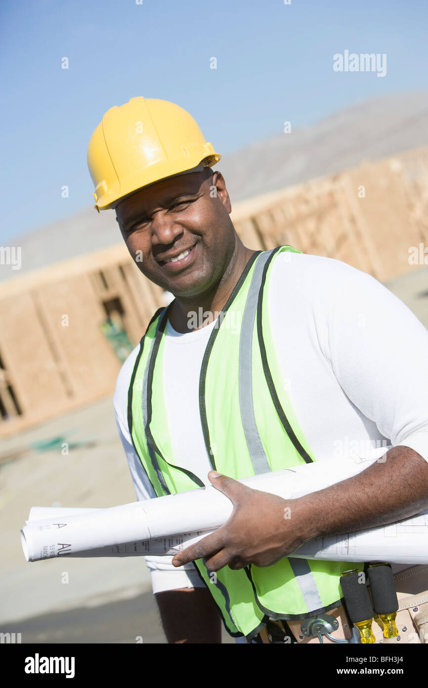 Construction worker holding blueprints Stock Photo - Alamy