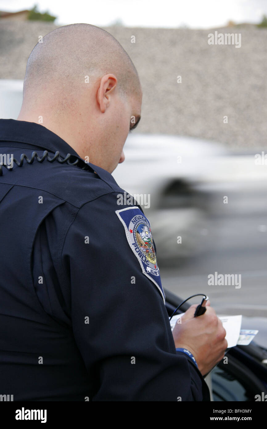 Nevada Highway Patrol State Trooper writing a ticket after stopping a driver for a traffic offence. Stock Photo