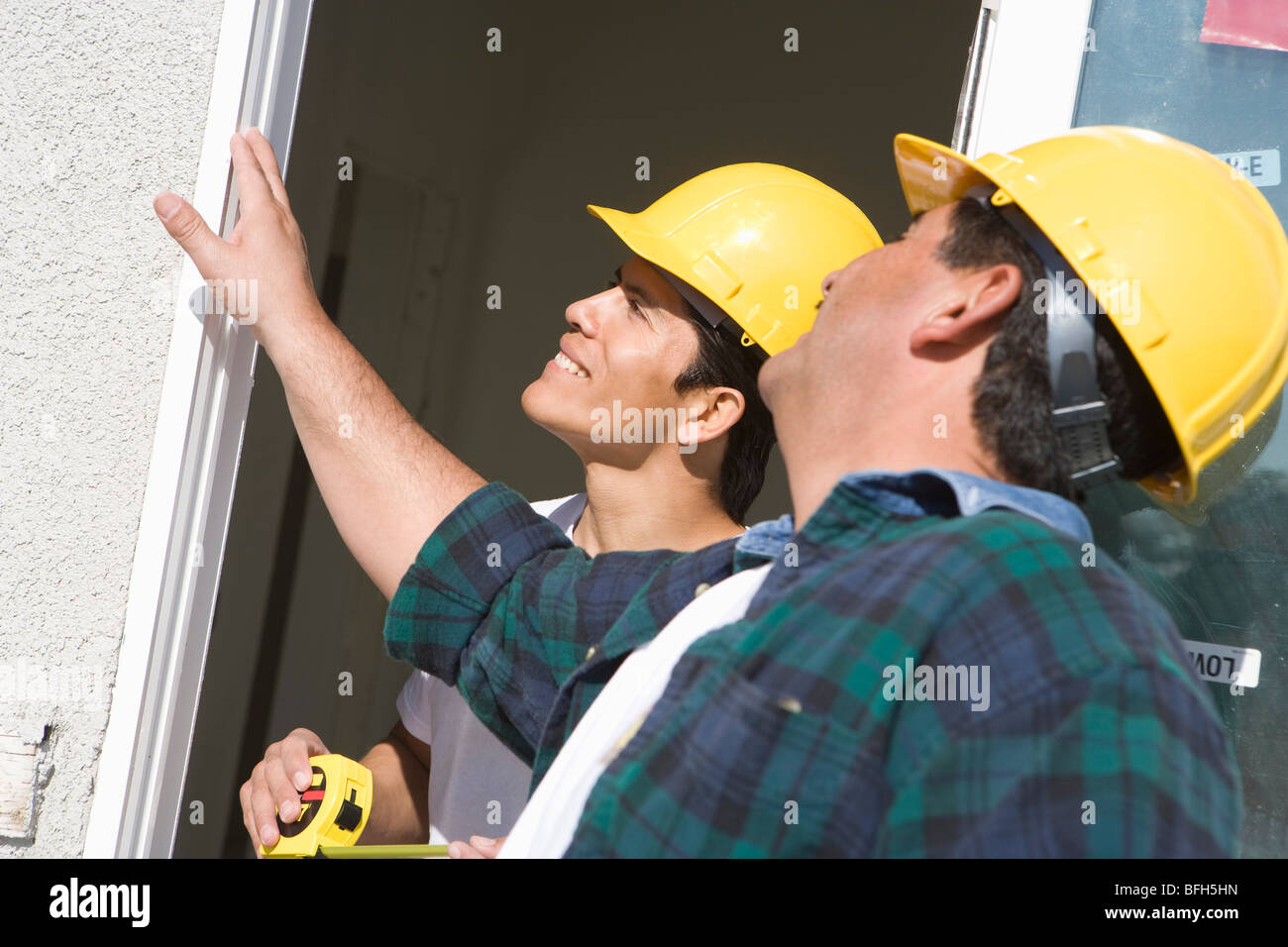 Construction Workers examining window frame Stock Photo - Alamy