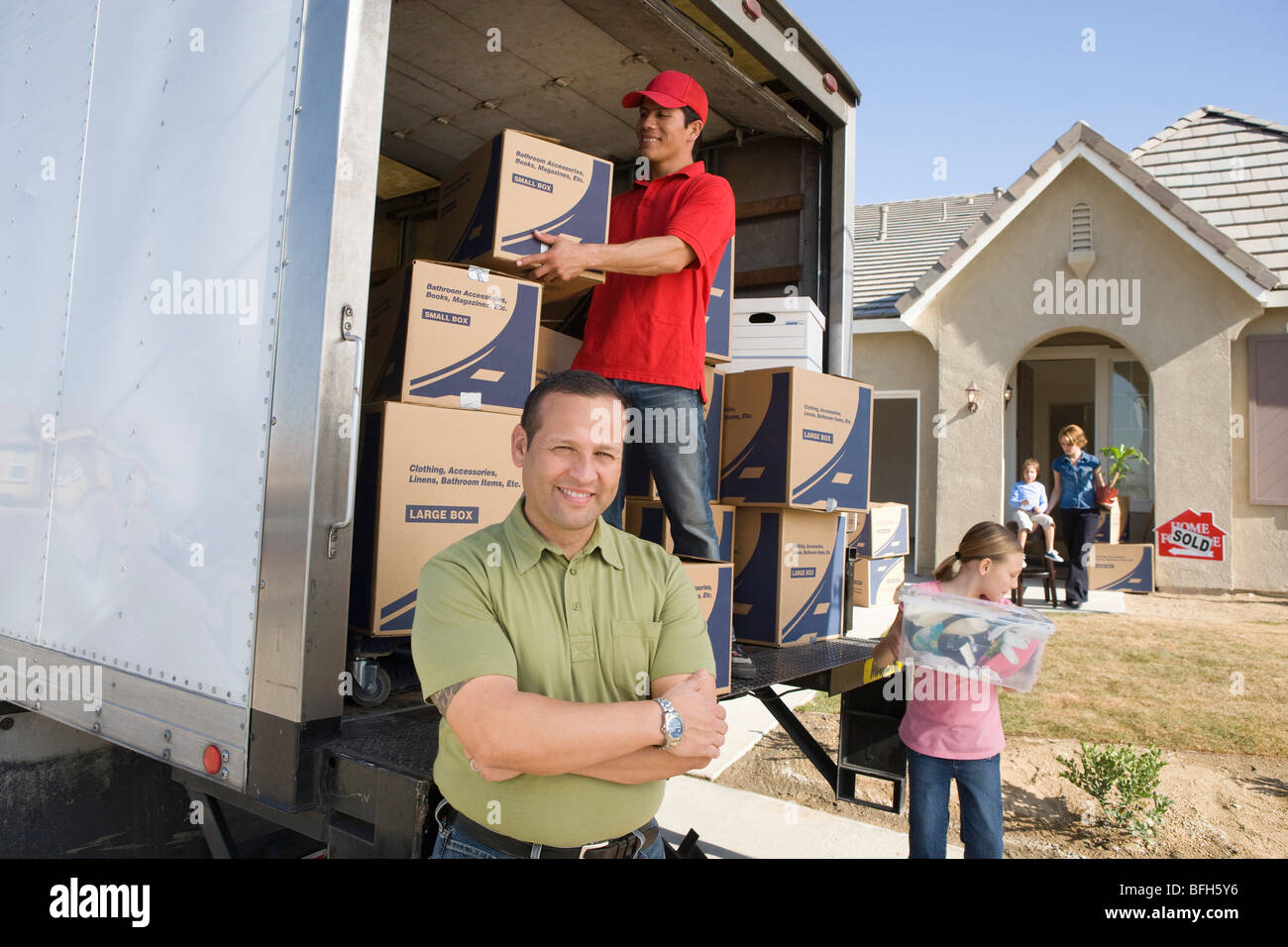Loading Truck With 4 People Family and worker unloading truck of cardboard boxes Stock Photo - Alamy