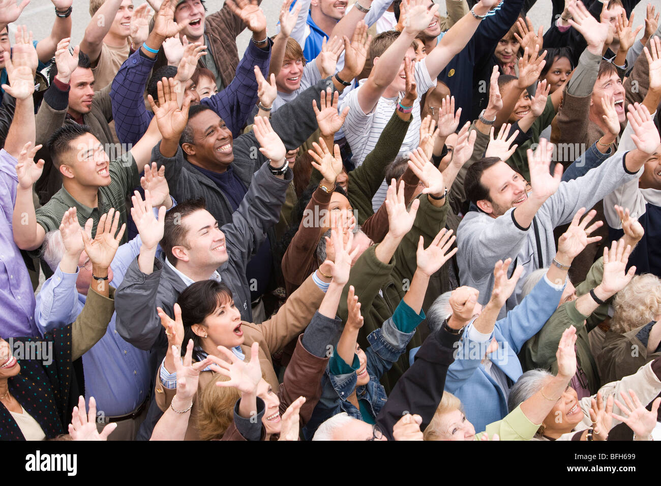 Crowd with arms raised Stock Photo