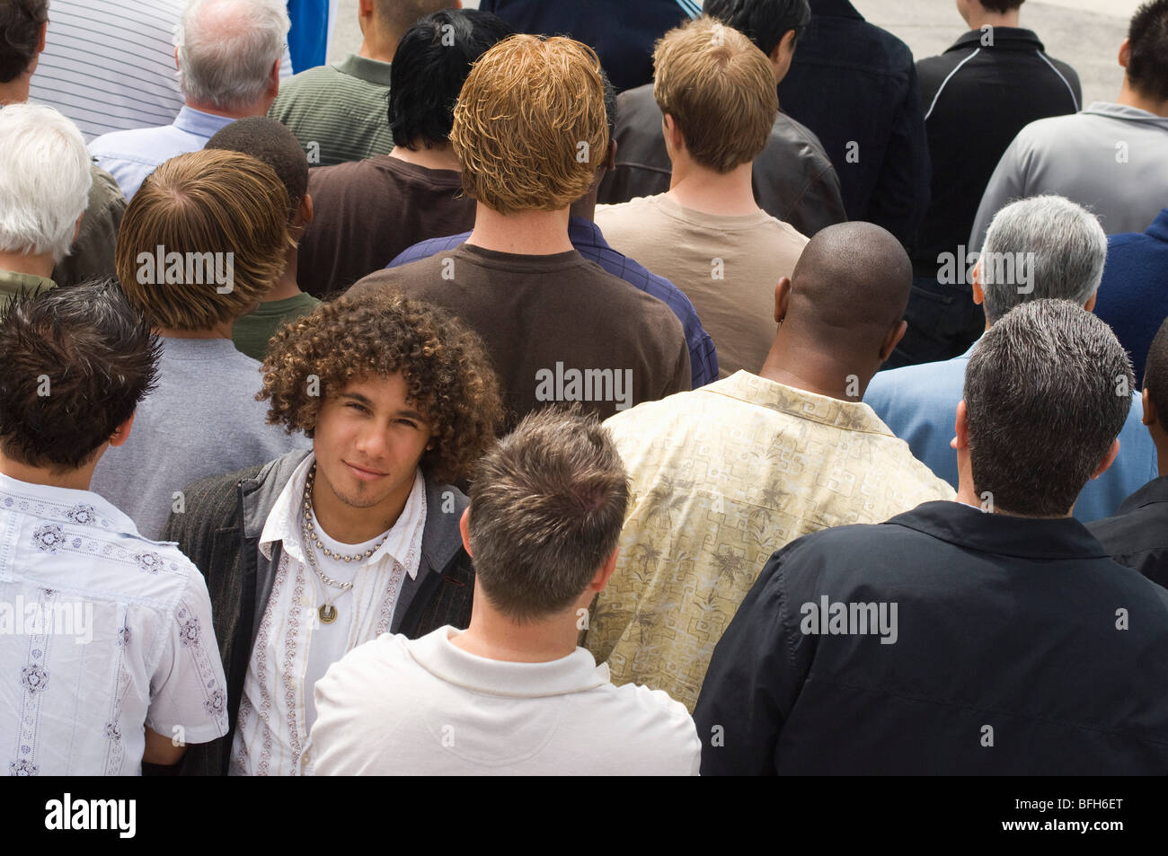Young man standing in crowd Stock Photo