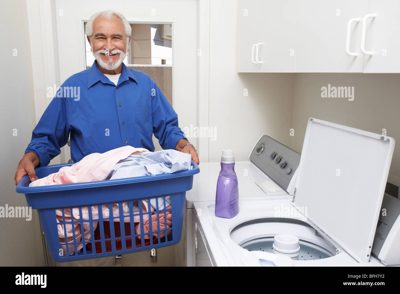 Elderly man with laundry basket Stock Photo Alamy