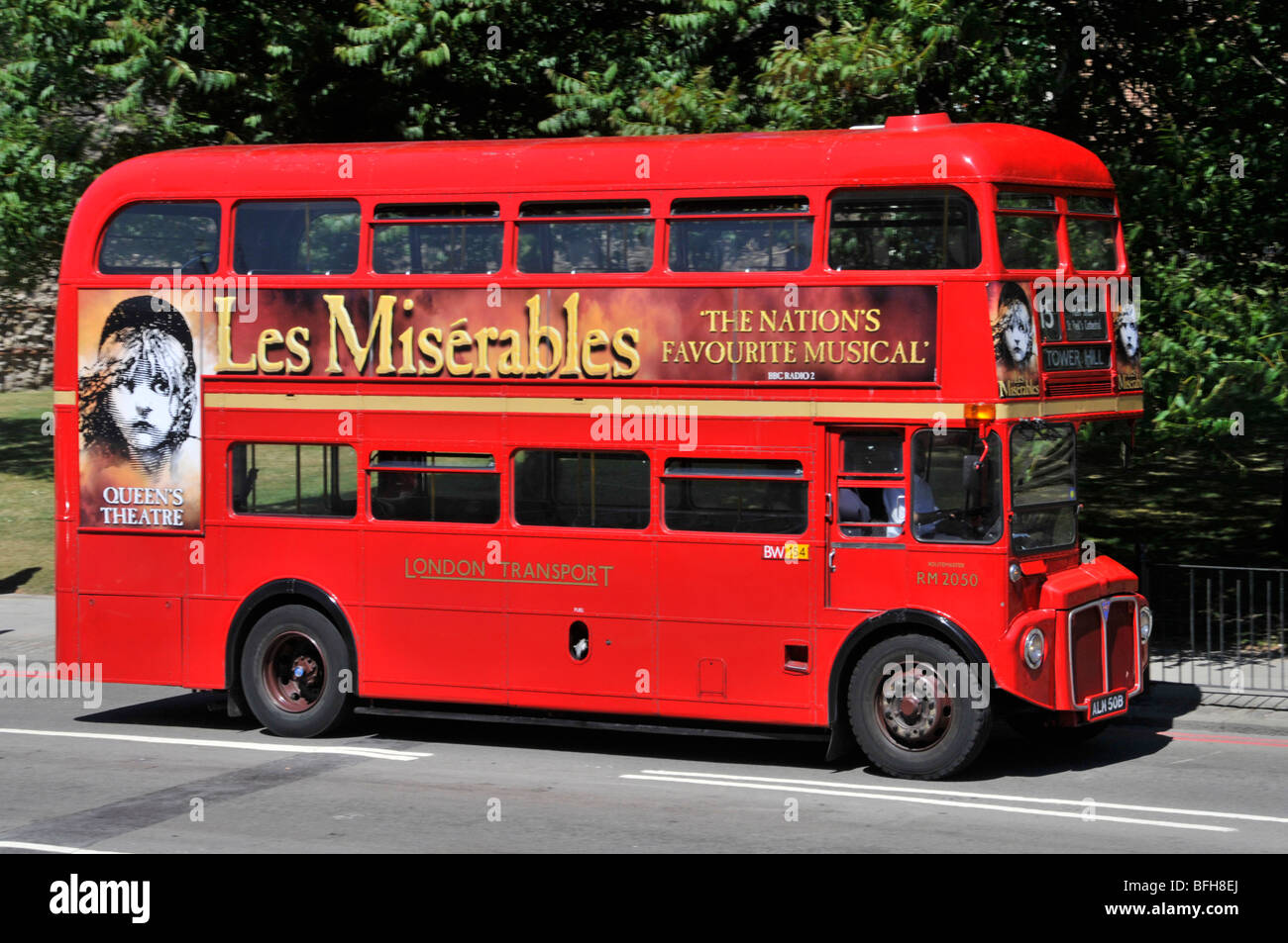 Side view red double decker classic iconic Routemaster London bus  advertising poster for famous Les Misérables musical at Queens Theatre England UK Stock Photo