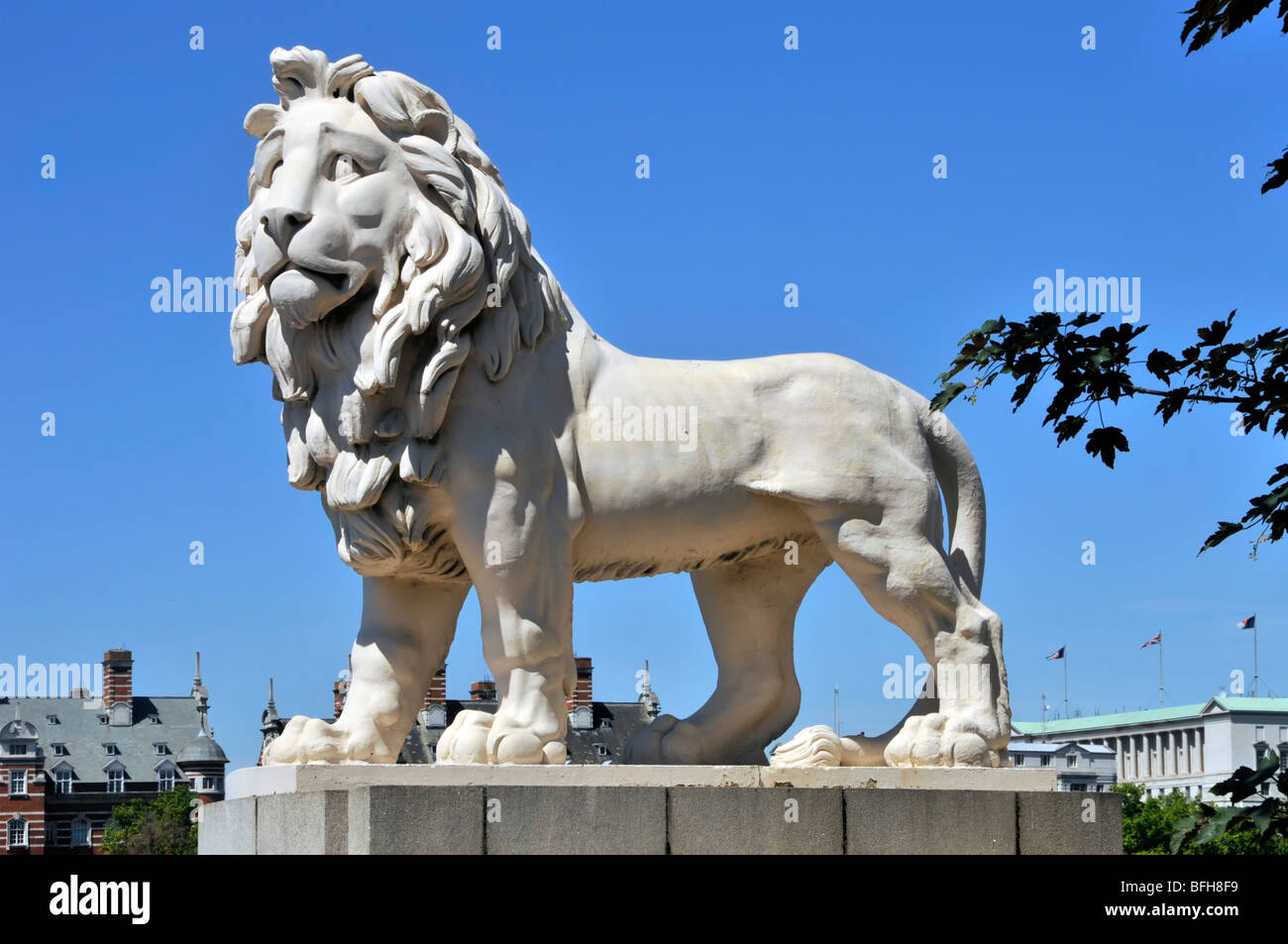 Historical statue of the South Bank Coade stone sculpture of male Lion on a blue sky day at the Lambeth end of  Westminster Bridge London England UK Stock Photo