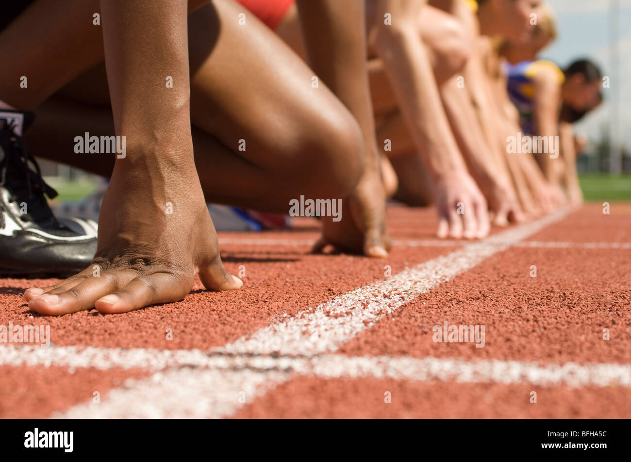 Group of female track athletes on starting blocks Stock Photo Alamy