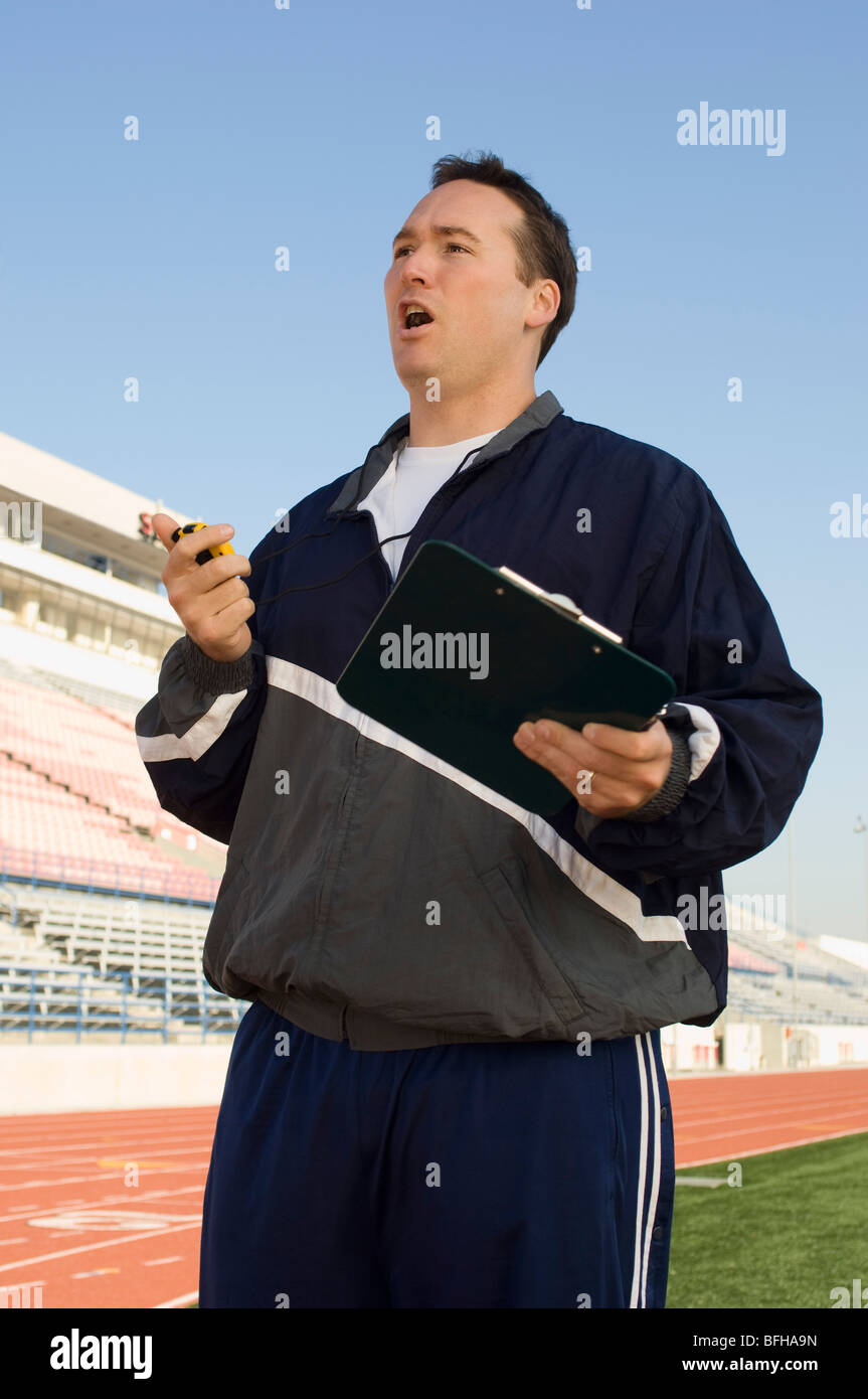 Sports coach looking at stopwatch Stock Photo Alamy