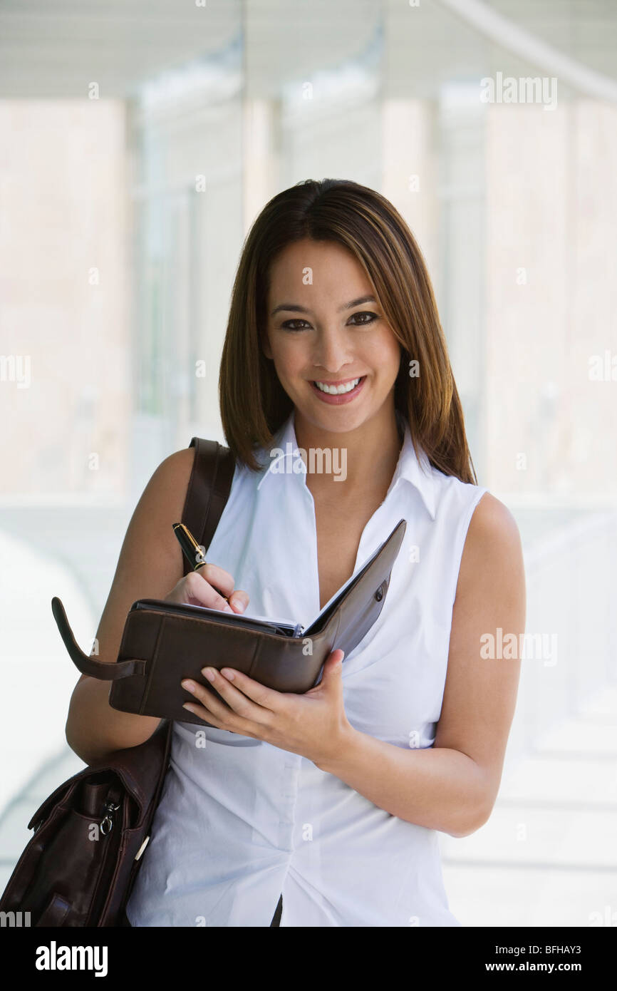 Woman writing in planner, portrait Stock Photo - Alamy