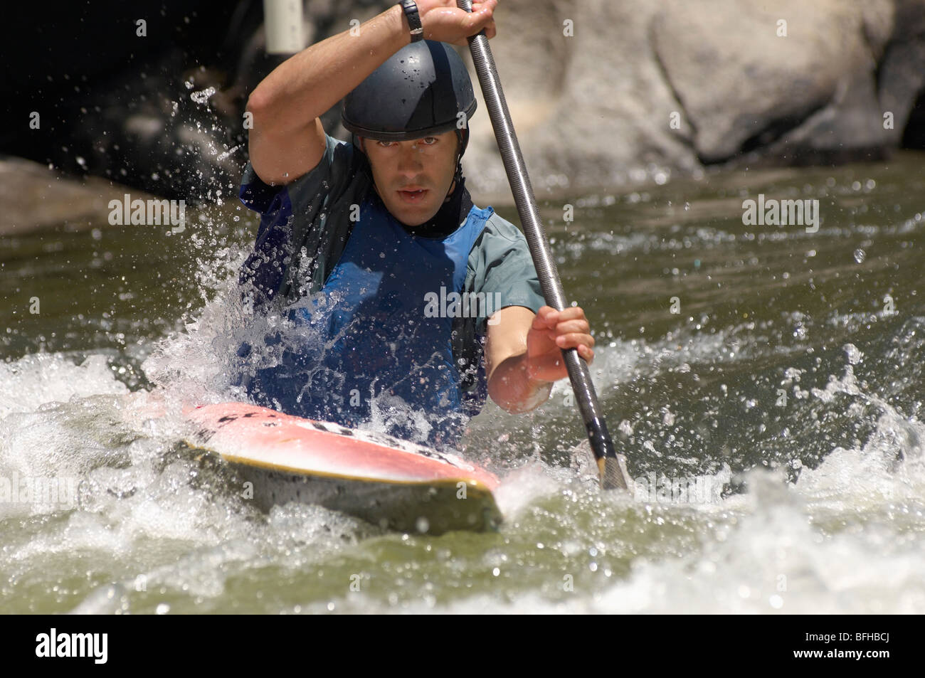 Young man whitewater kayaking Stock Photo