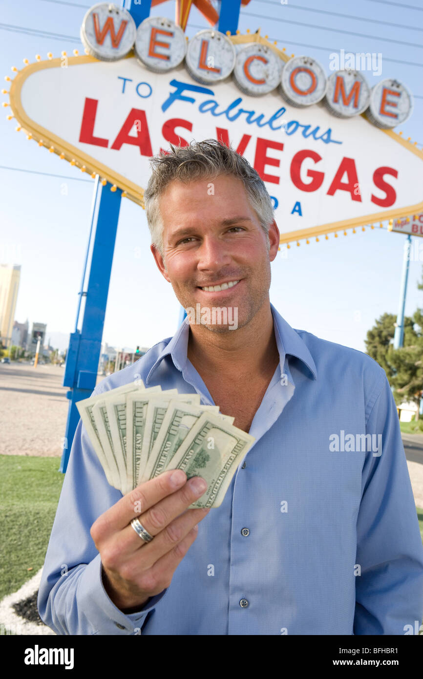 Mid-adult man holding notes in front of Welcome to Las Vegas sign, portrait Stock Photo