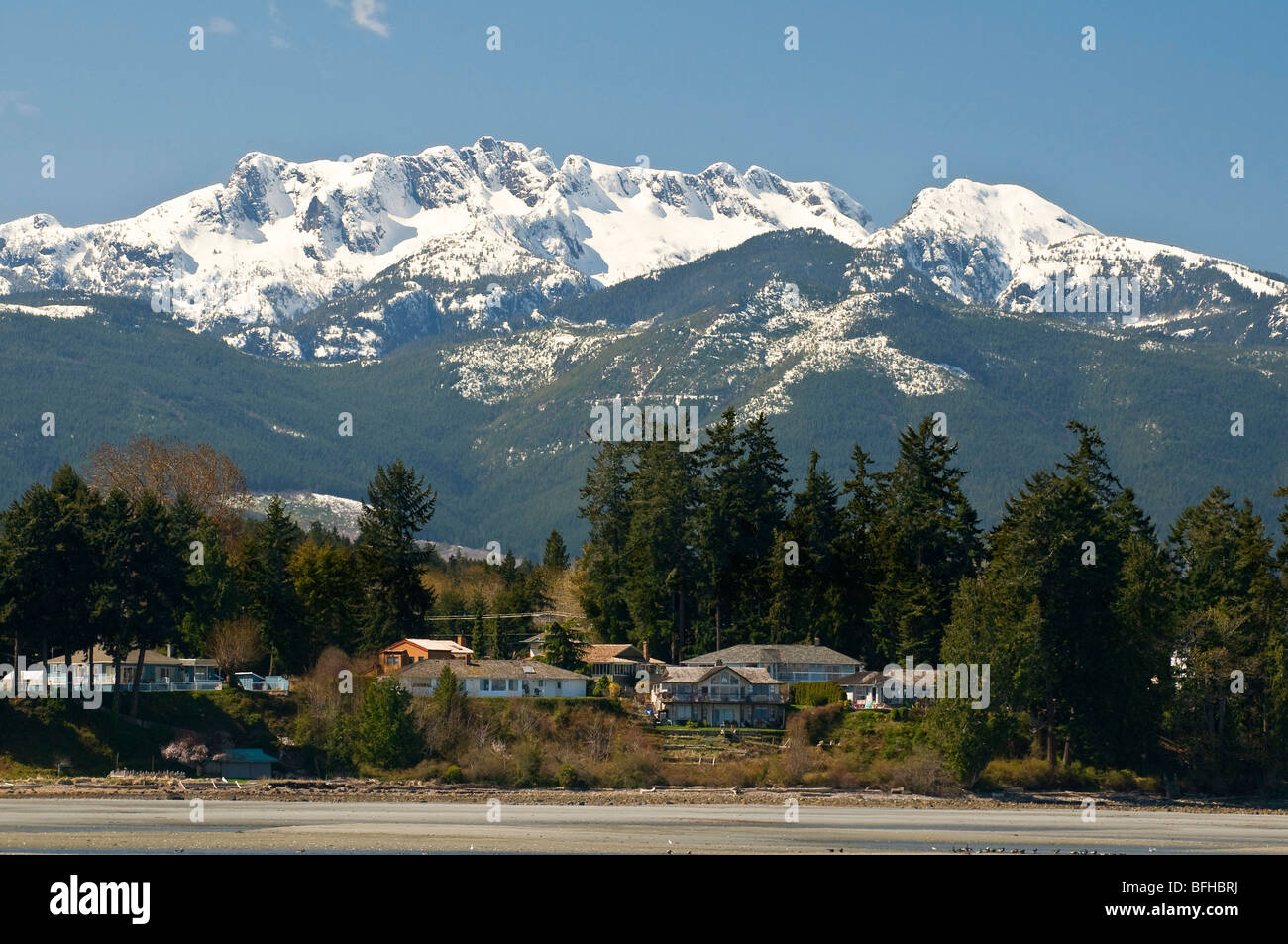 Snow-capped Mount Arrowsmith looms over the beach at Parksville BC. Stock Photo