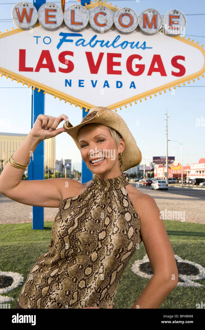 Mid-adult woman wearing cowboy hat in front of Welcome to Las Vegas sign, portrait Stock Photo