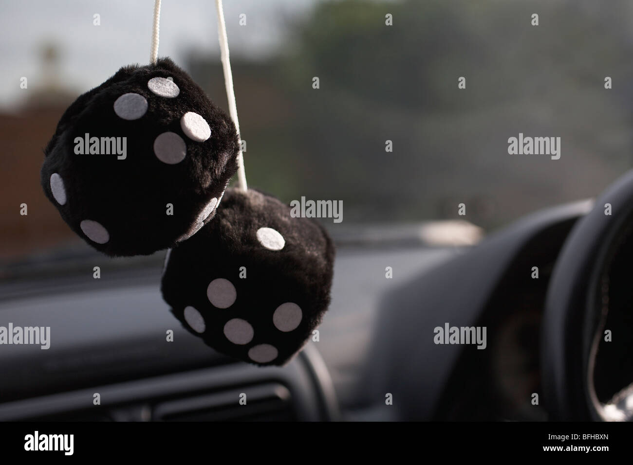Furry dice hanging in car Stock Photo