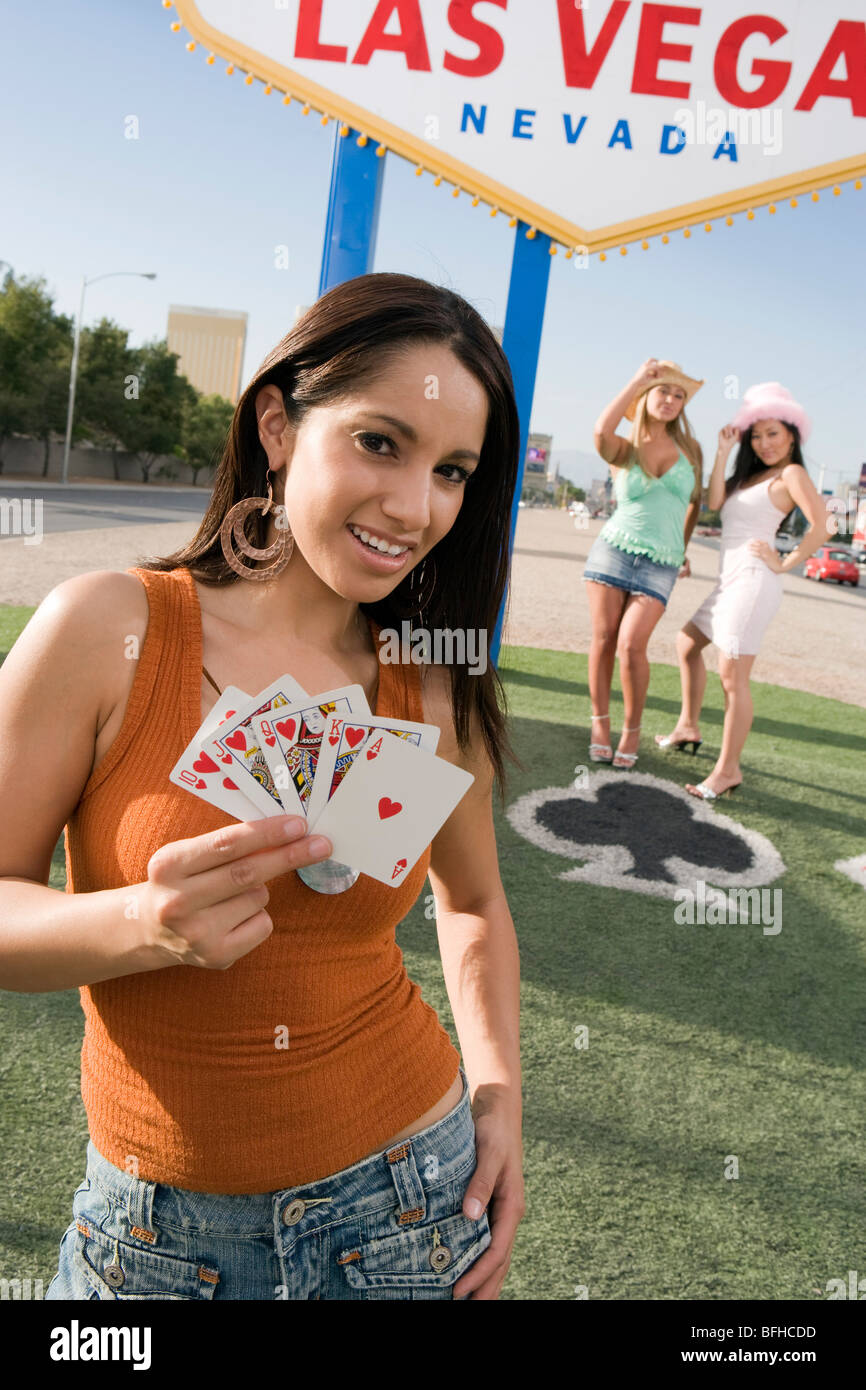 Woman holding cards in front of Las Vegas welcome sign, Nevada, USA Stock Photo