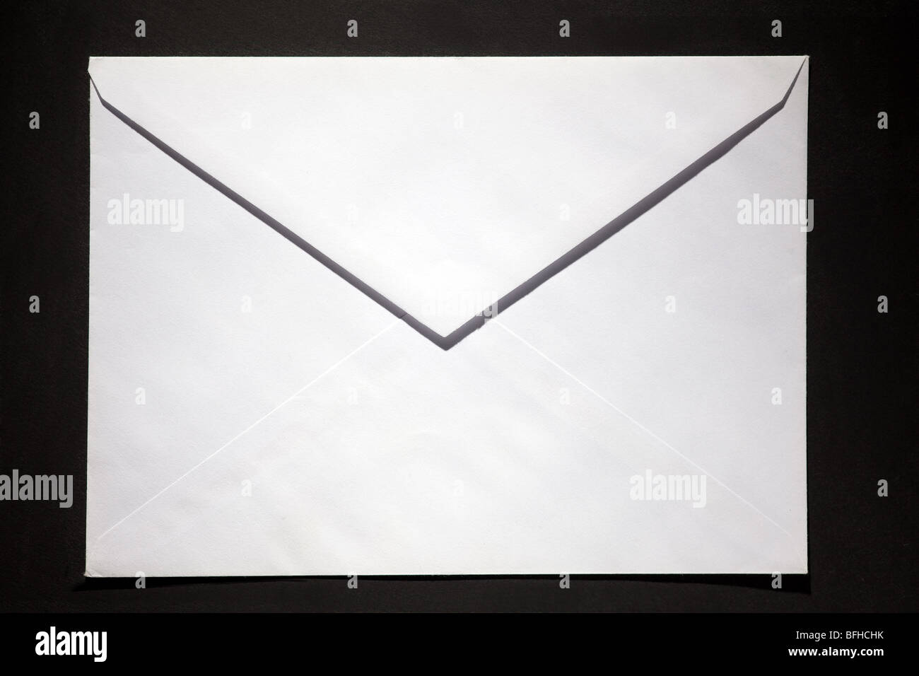 closed envelope with white spot light on black background Stock Photo ...