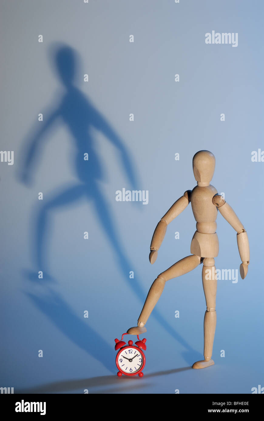 wooden model and red alarm clock,metaphor of stopping the time Stock