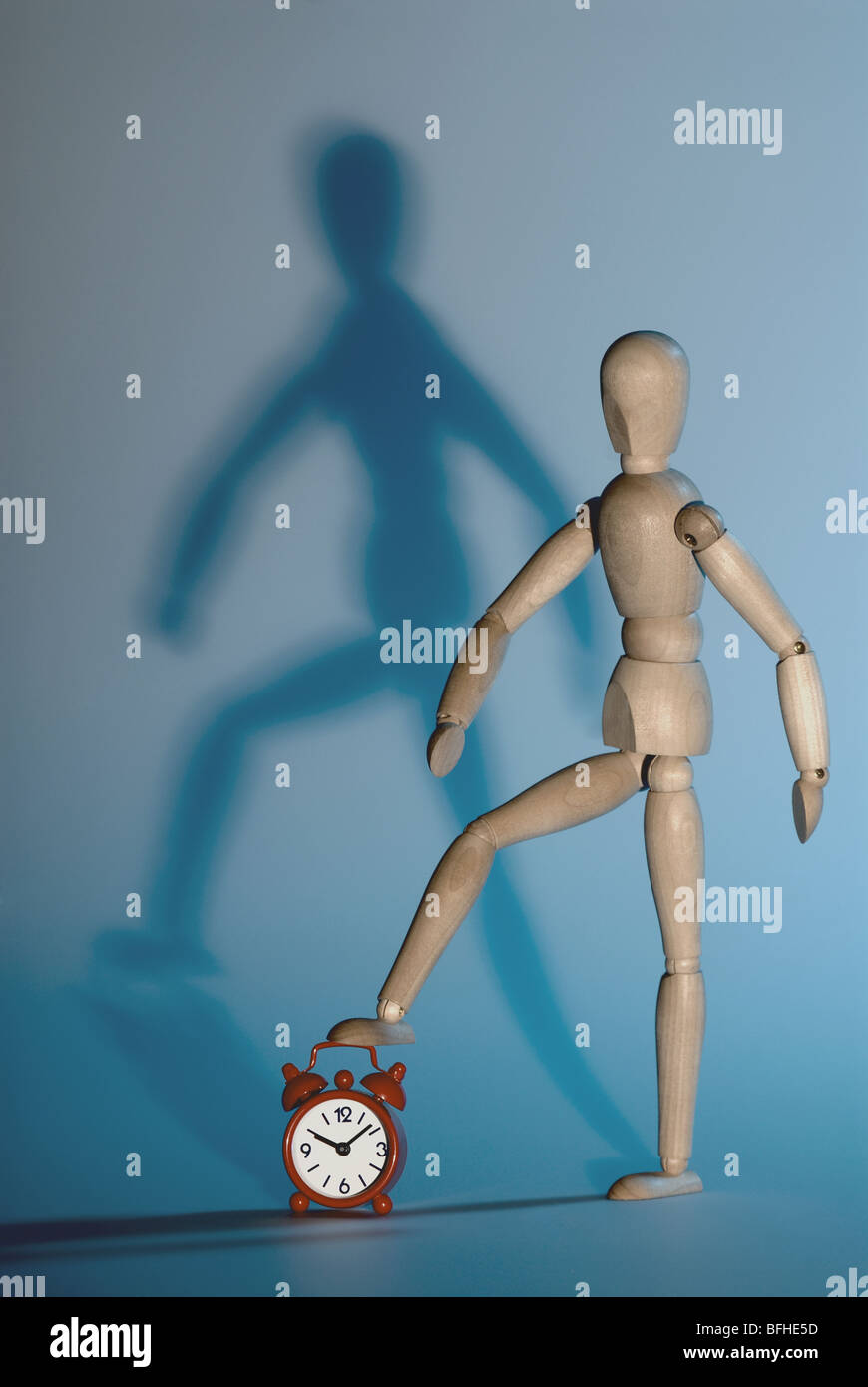 wooden model and red alarm clock,metaphor of stopping the time Stock