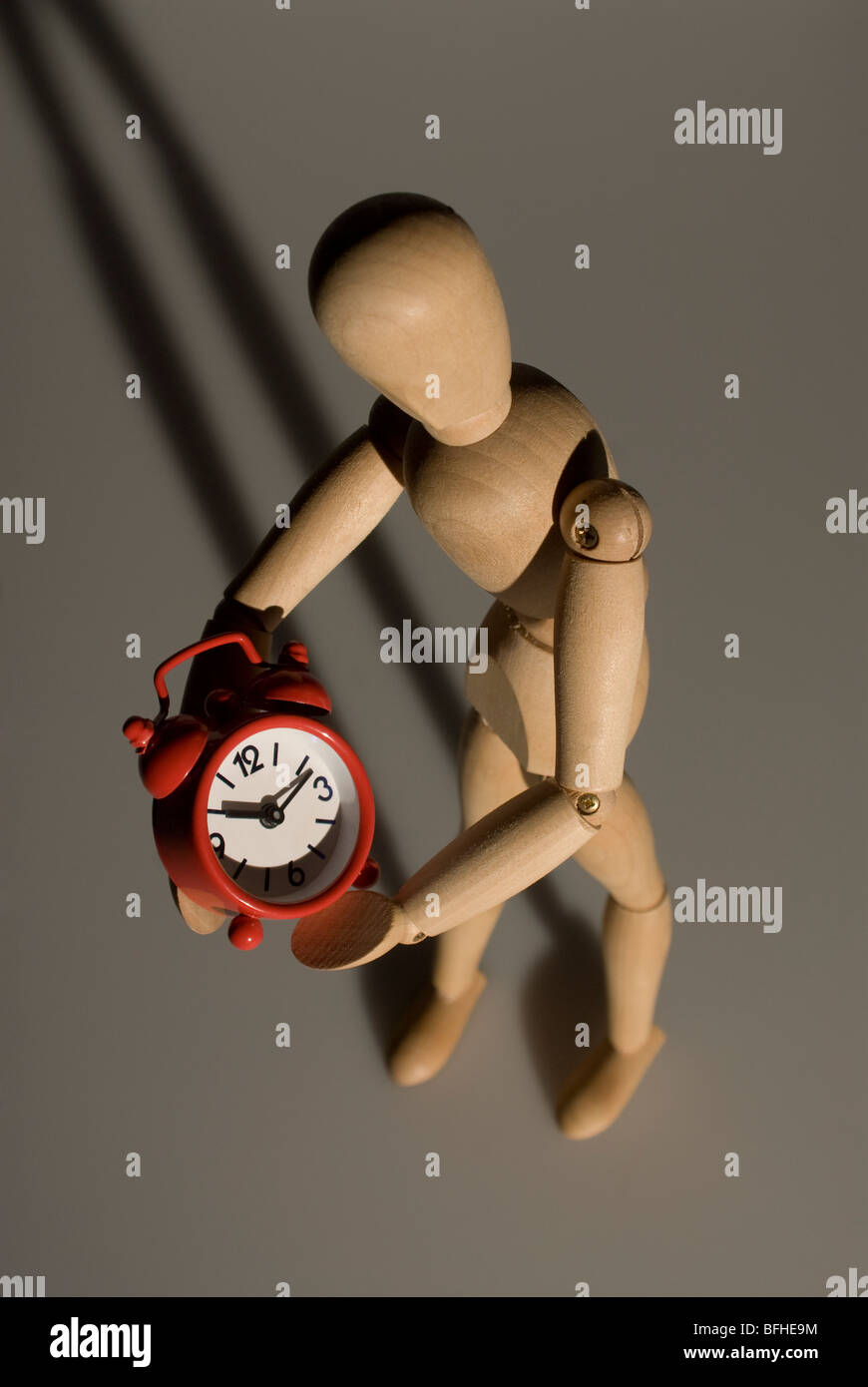 wooden model and red alarm clock,metaphor of stopping the time Stock