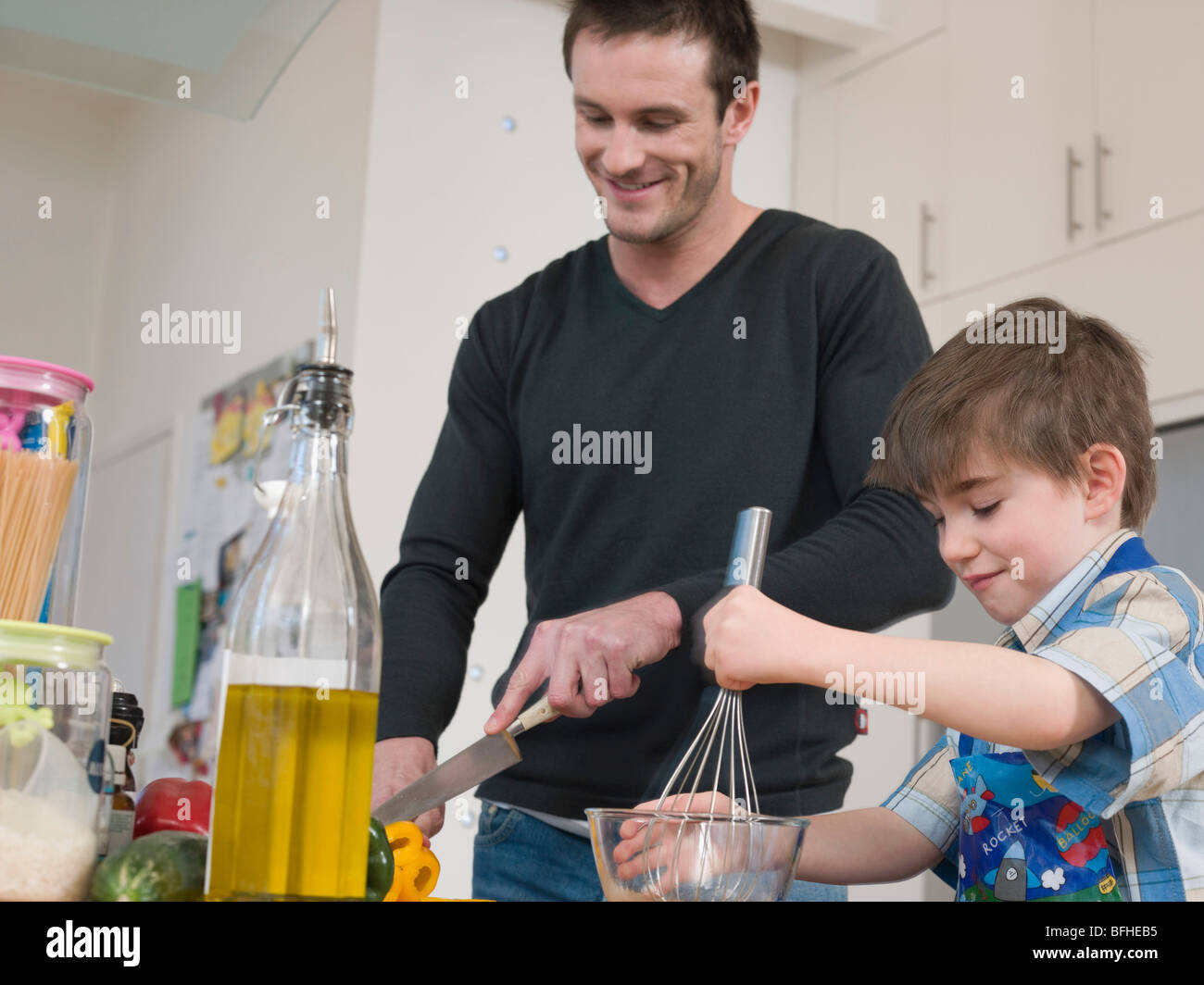 Son Helping Father in Kitchen Stock Photo - Alamy