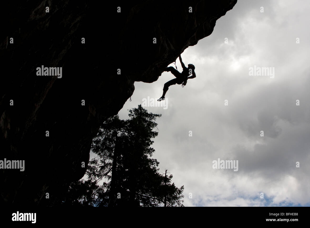 A rock climber reaches for chalk while trying to complete a challenge rout. Stock Photo
