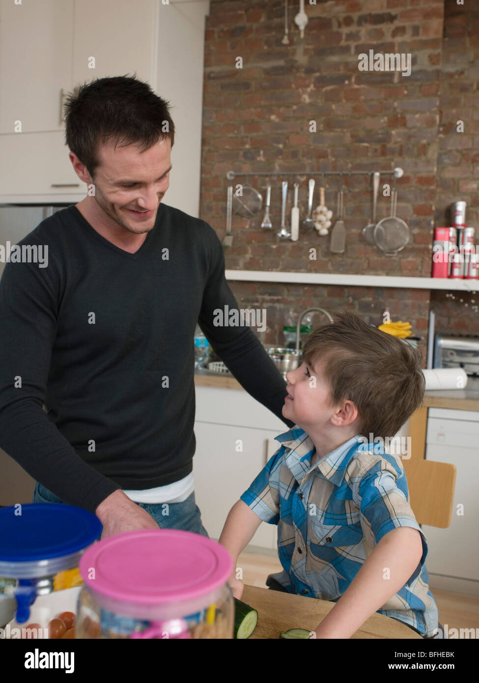 Son Helping Father in Kitchen Stock Photo - Alamy