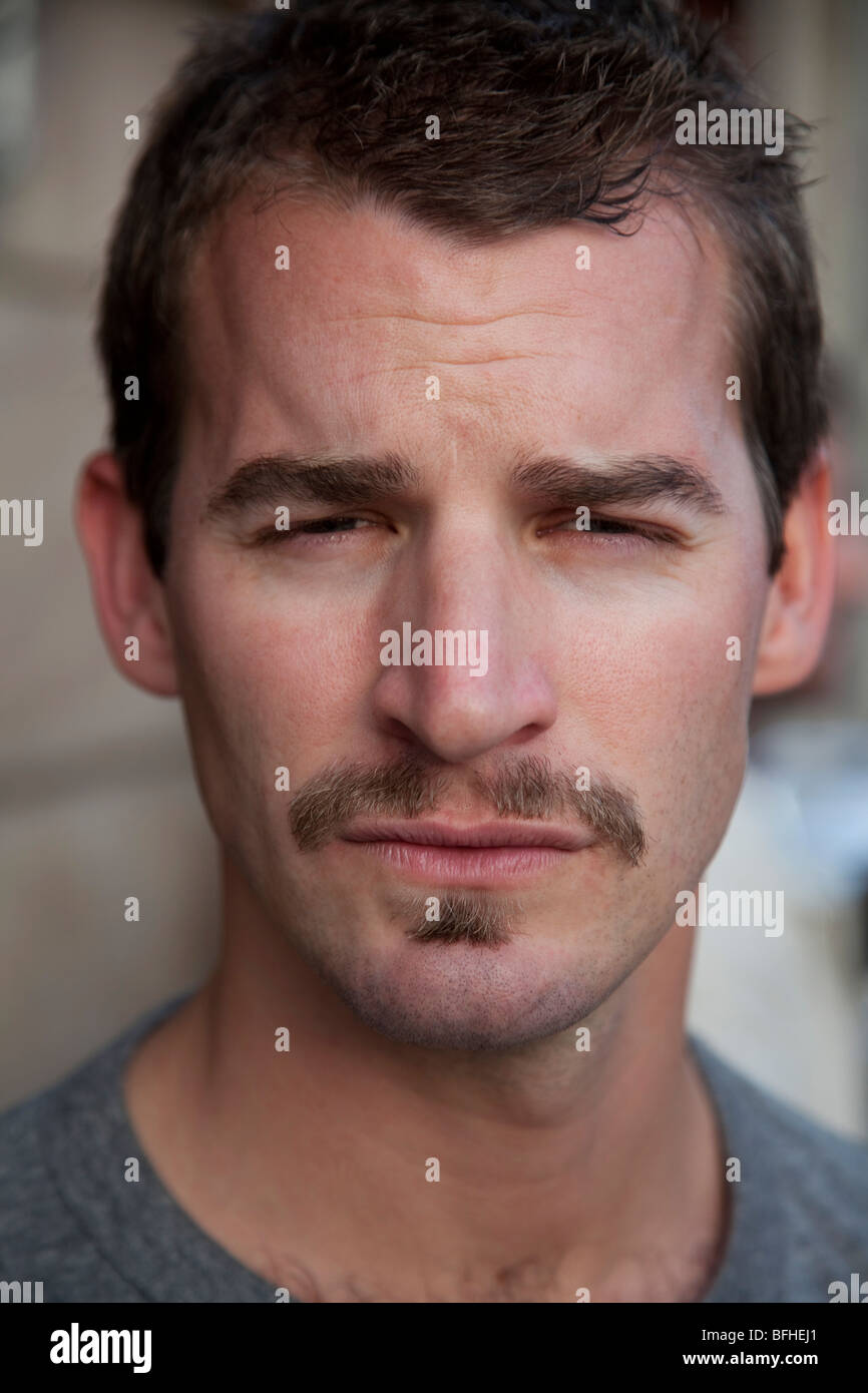 portrait of a young man squinting Stock Photo