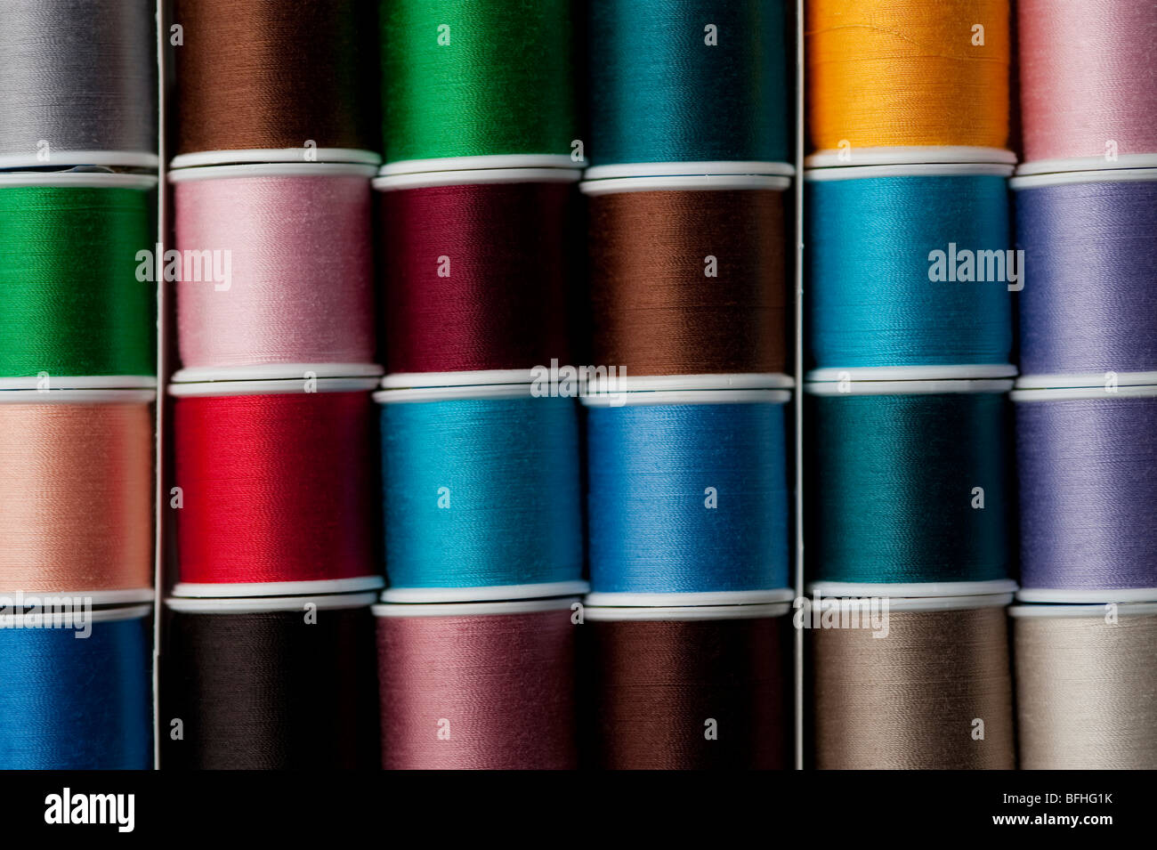 Bright colored spools of thread in rows Stock Photo - Alamy