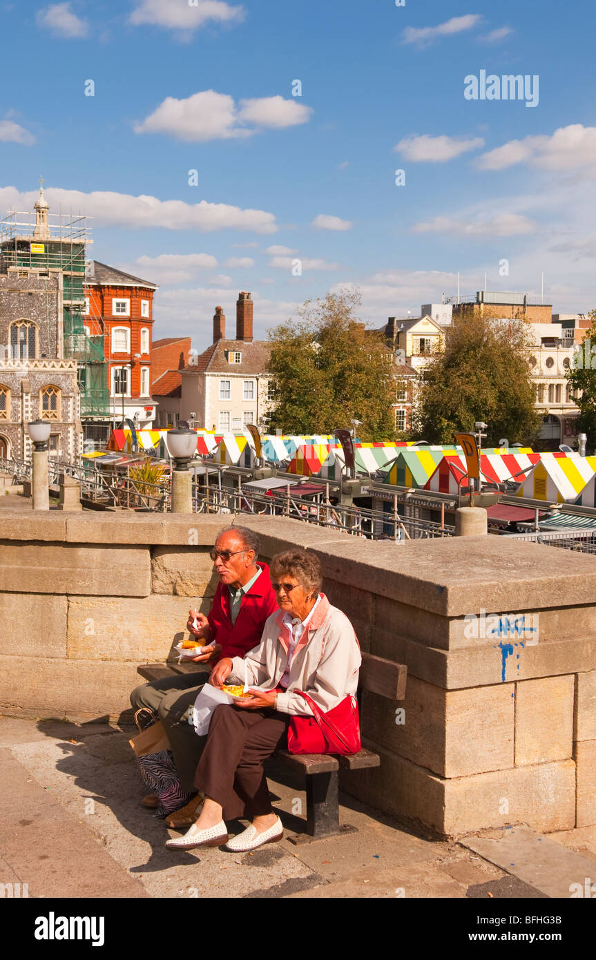 An elderly couple eating Fish & Chips from the market in Norwich,Norfolk,Uk Stock Photo