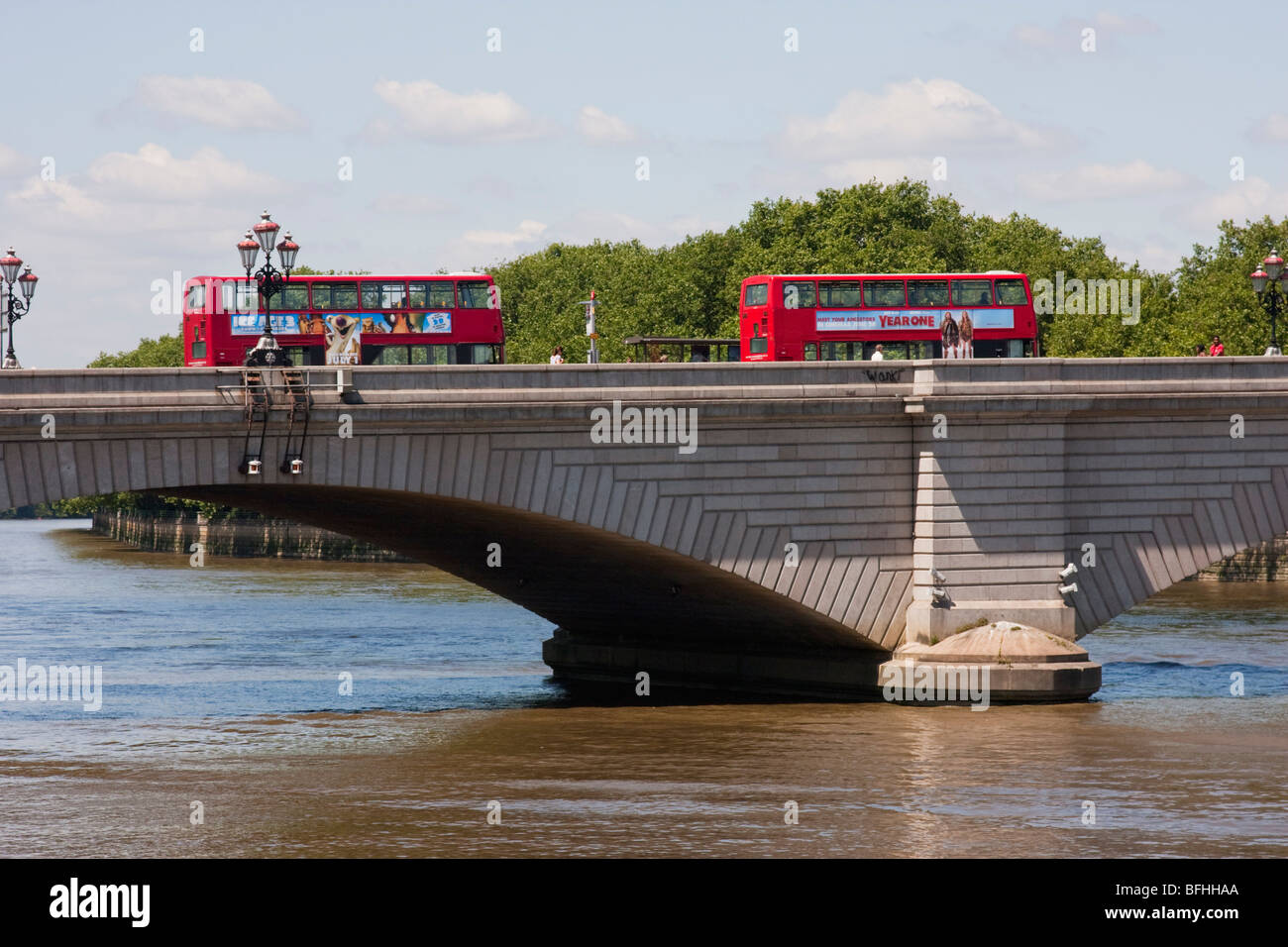 Two red buses cross Putney Bridge on a sunny summer day. Stock Photo