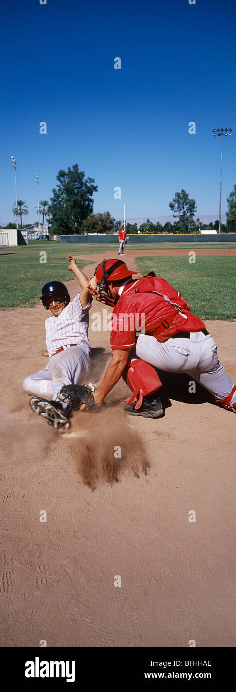 Baseball player sliding into base Stock Photo