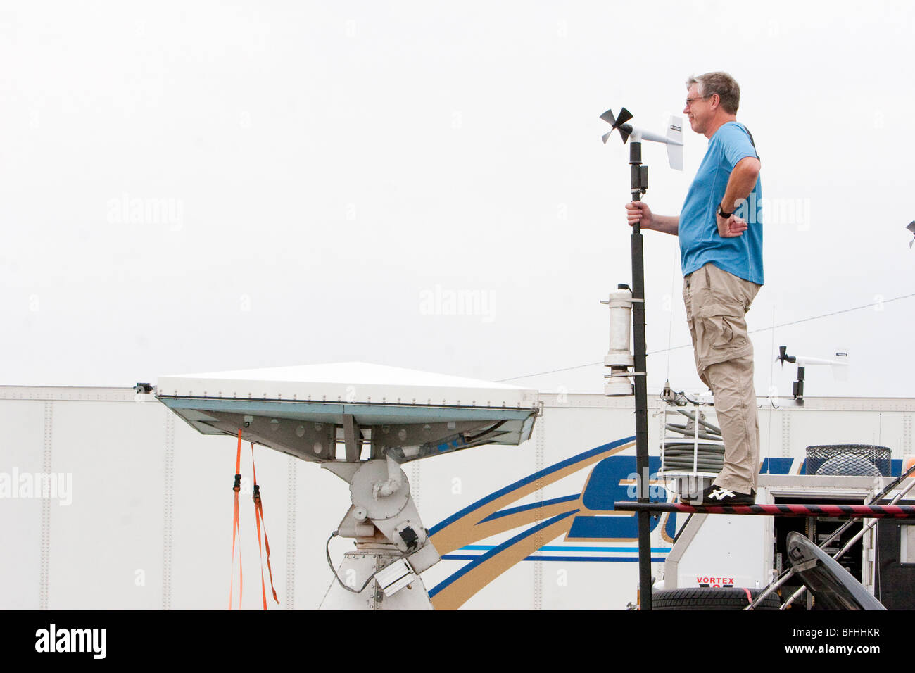 Storm chaser Phil Berg adjusts an anemometer atop his storm chasing