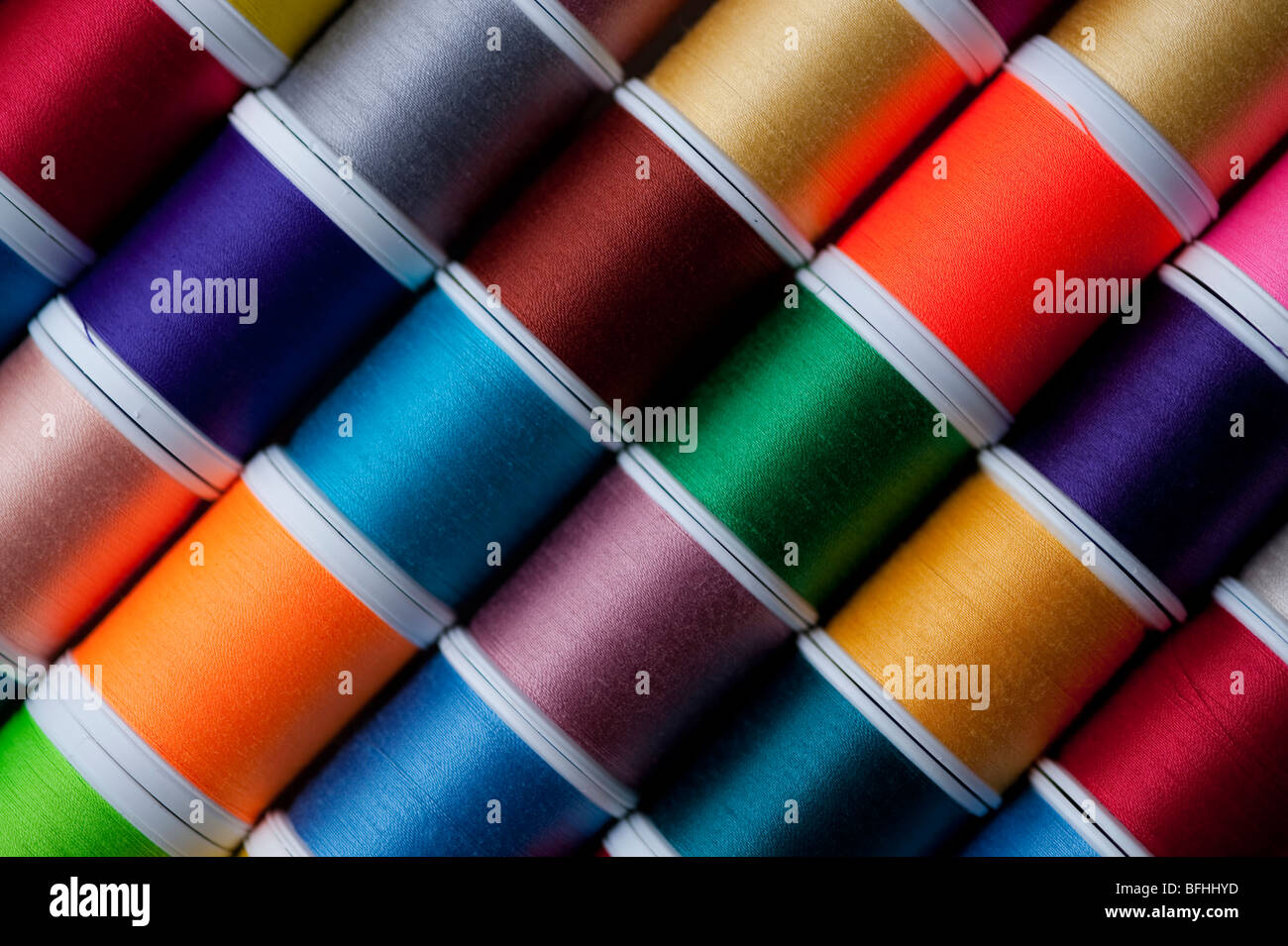 Bright colored spools of thread in rows Stock Photo - Alamy