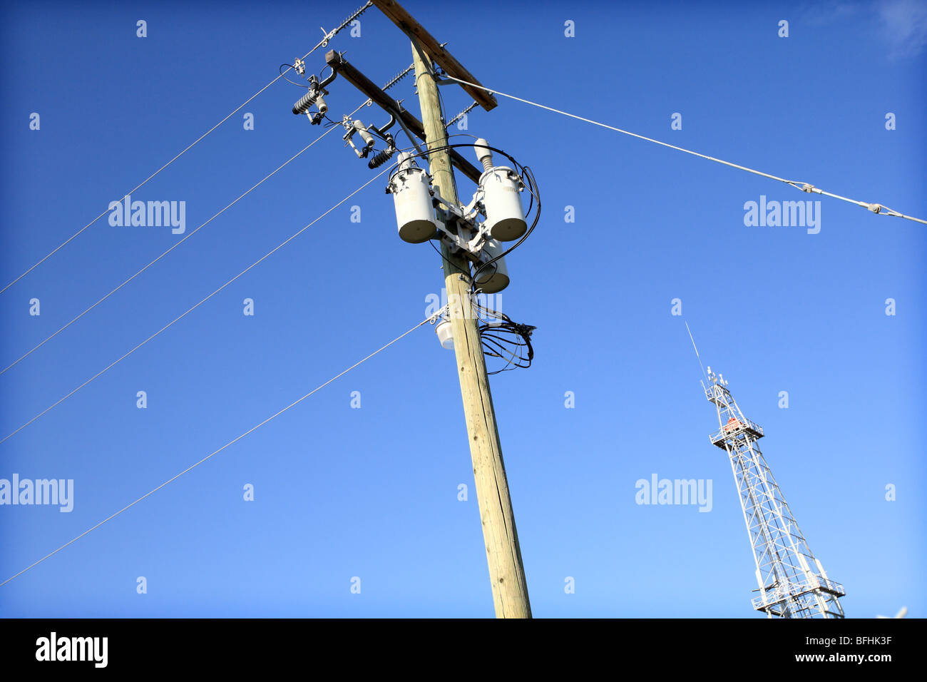 Power lines and oil drilling derrick. Stock Photo