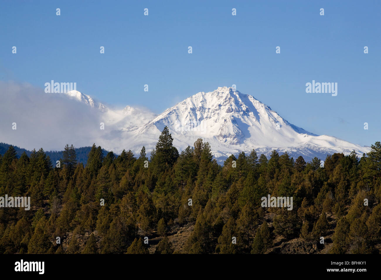 Ponderosa pine and juniper dot the lower slopes of the Cascade Mountains in winter near Bend, Oregon Stock Photo