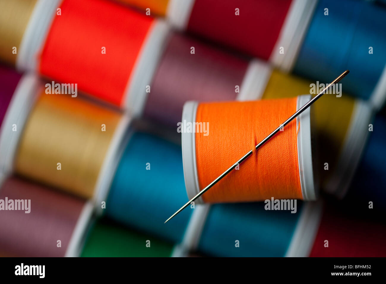 Bright colored spools of thread with sewing needle Stock Photo