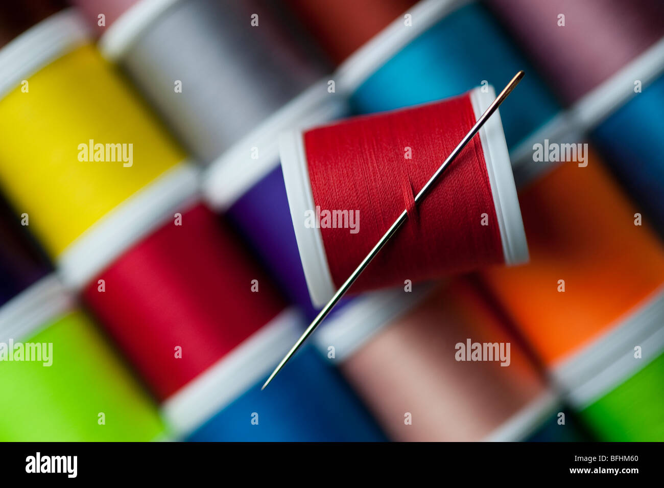 Bright colored spools of thread with sewing needle Stock Photo - Alamy