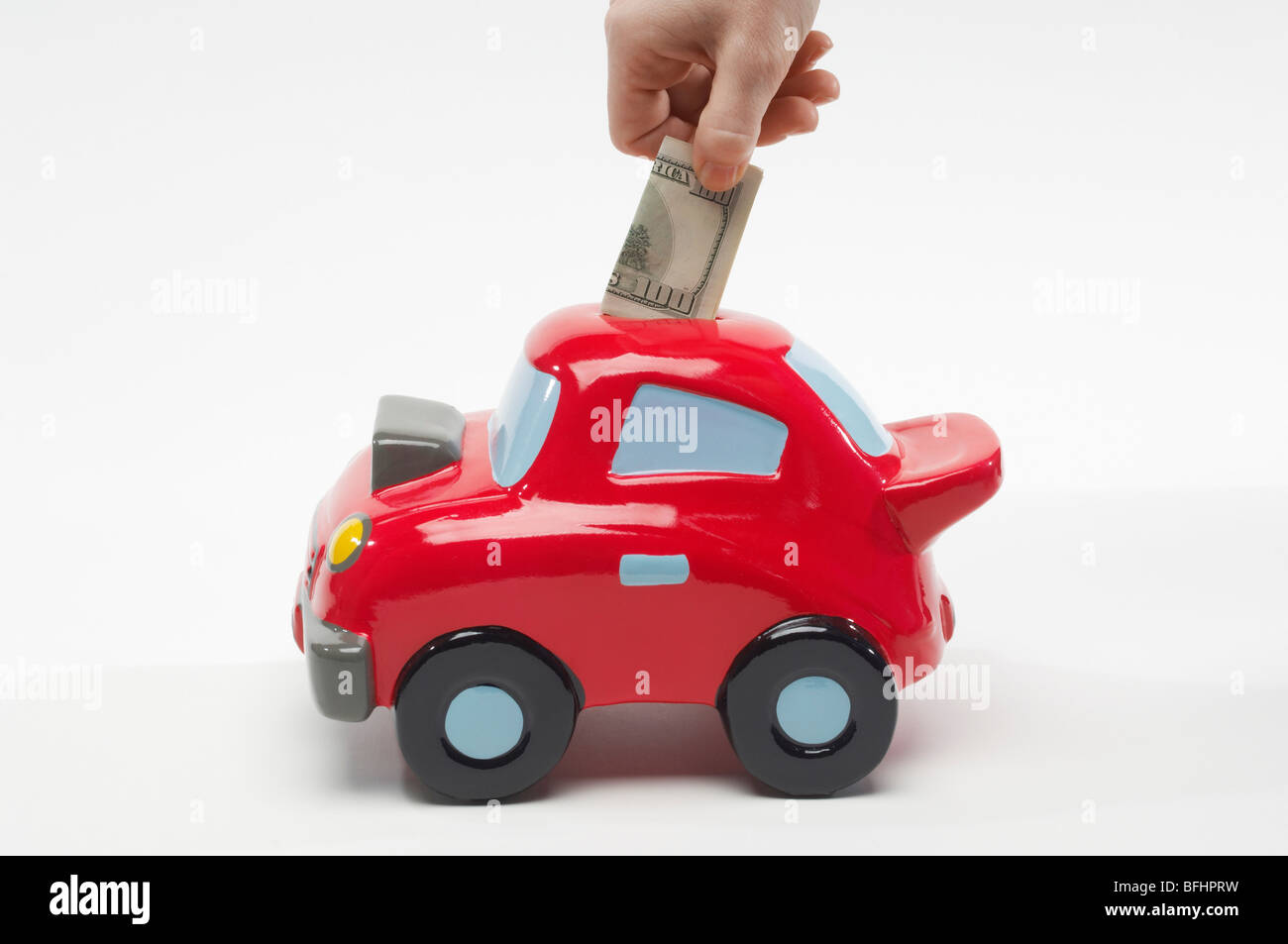 Hand Putting Money in Car Shaped Piggy Bank Stock Photo Alamy