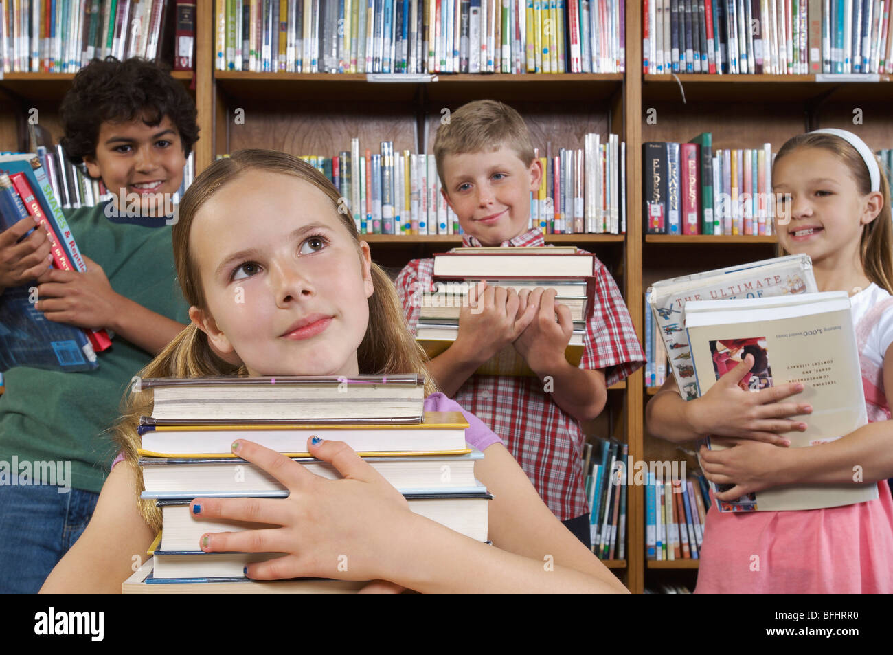 School children holding books in library Stock Photo - Alamy