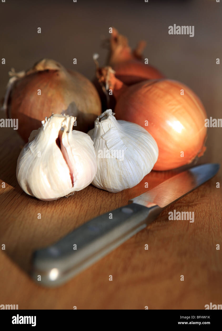 Onions and garlic bulbs with a kitchen knife Stock Photo Alamy