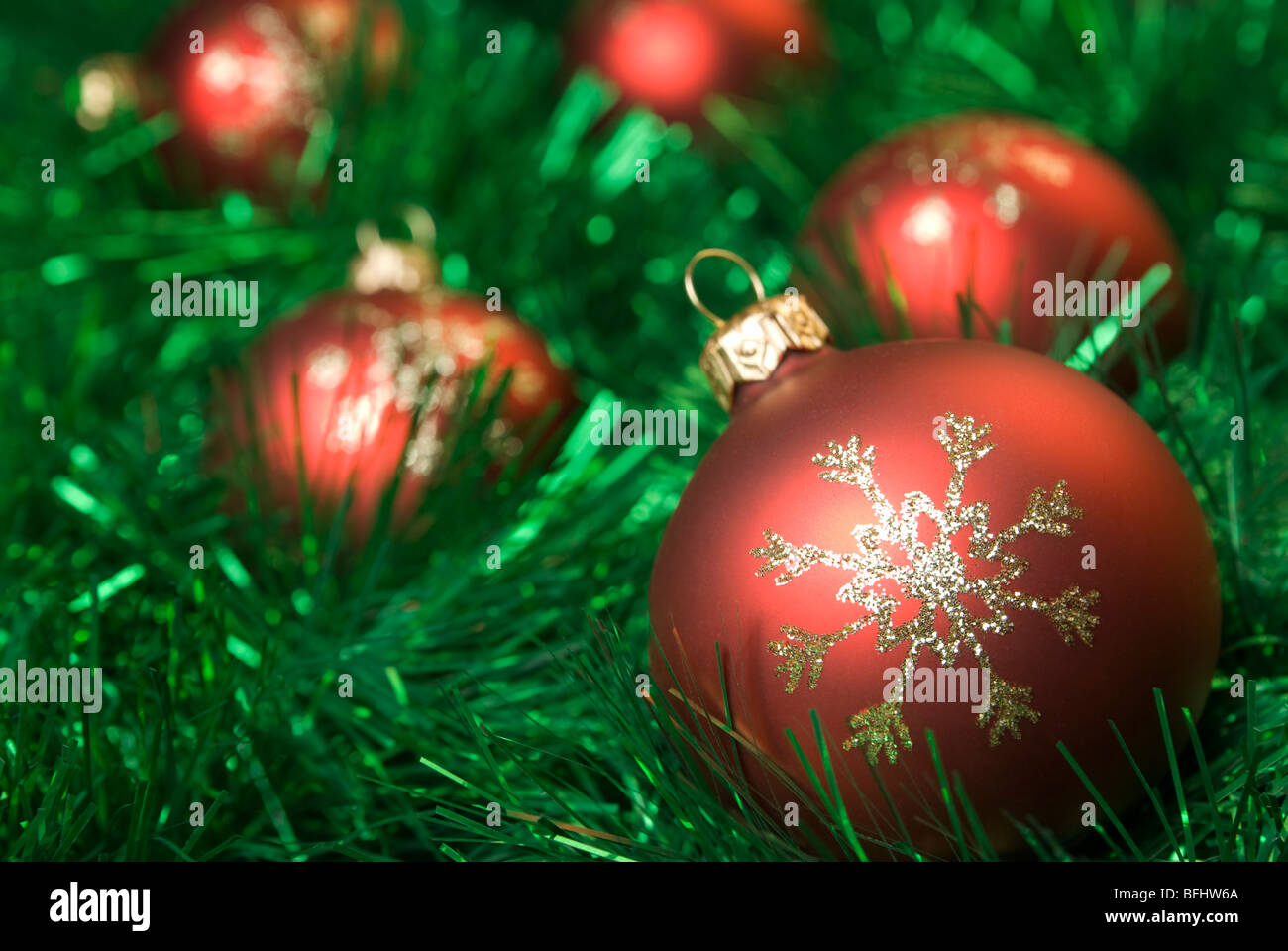 Red christmas balls on the green tinsel. aRGB. Stock Photo