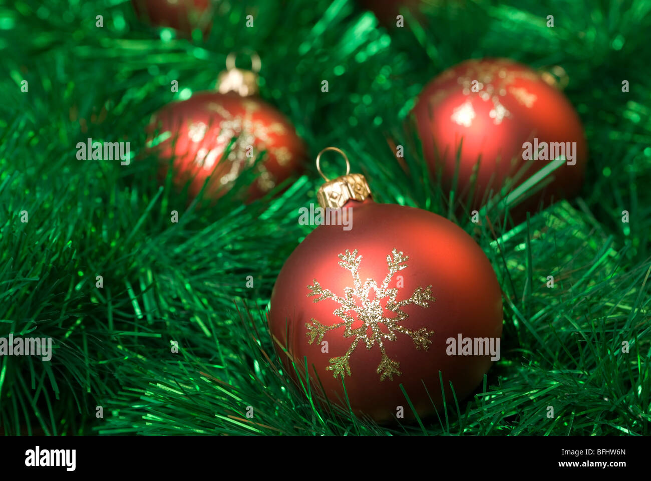 Red christmas balls on the green tinsel. aRGB. Stock Photo